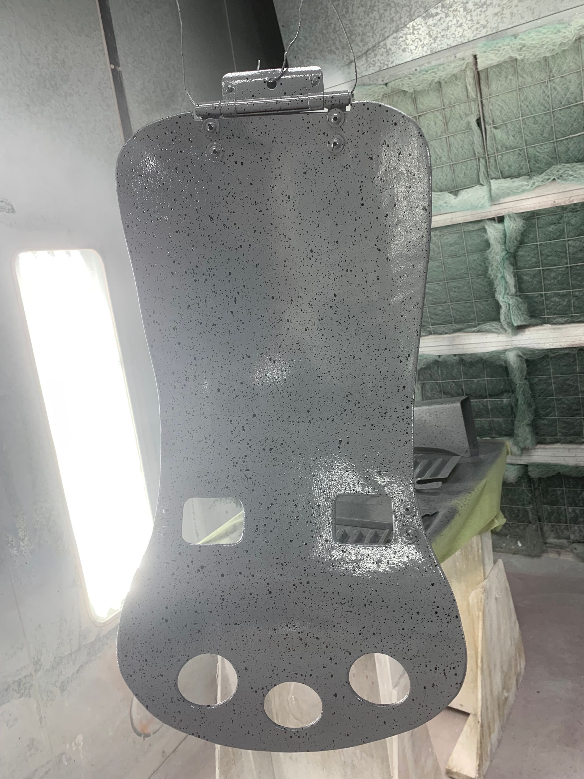 A piece of metal with holes in it is sitting on a table.