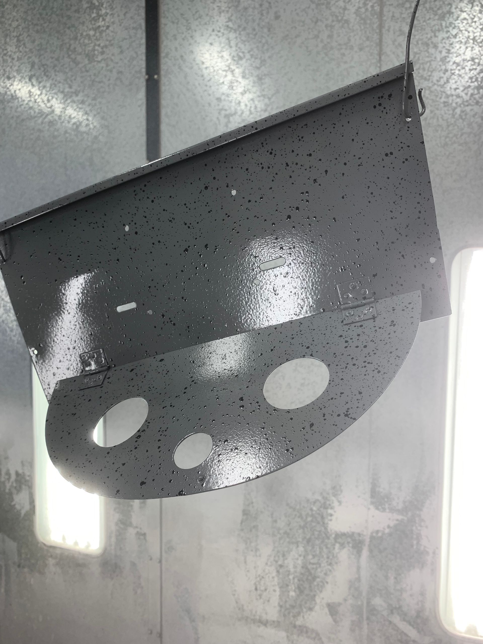 A piece of metal is hanging from the ceiling in a room.