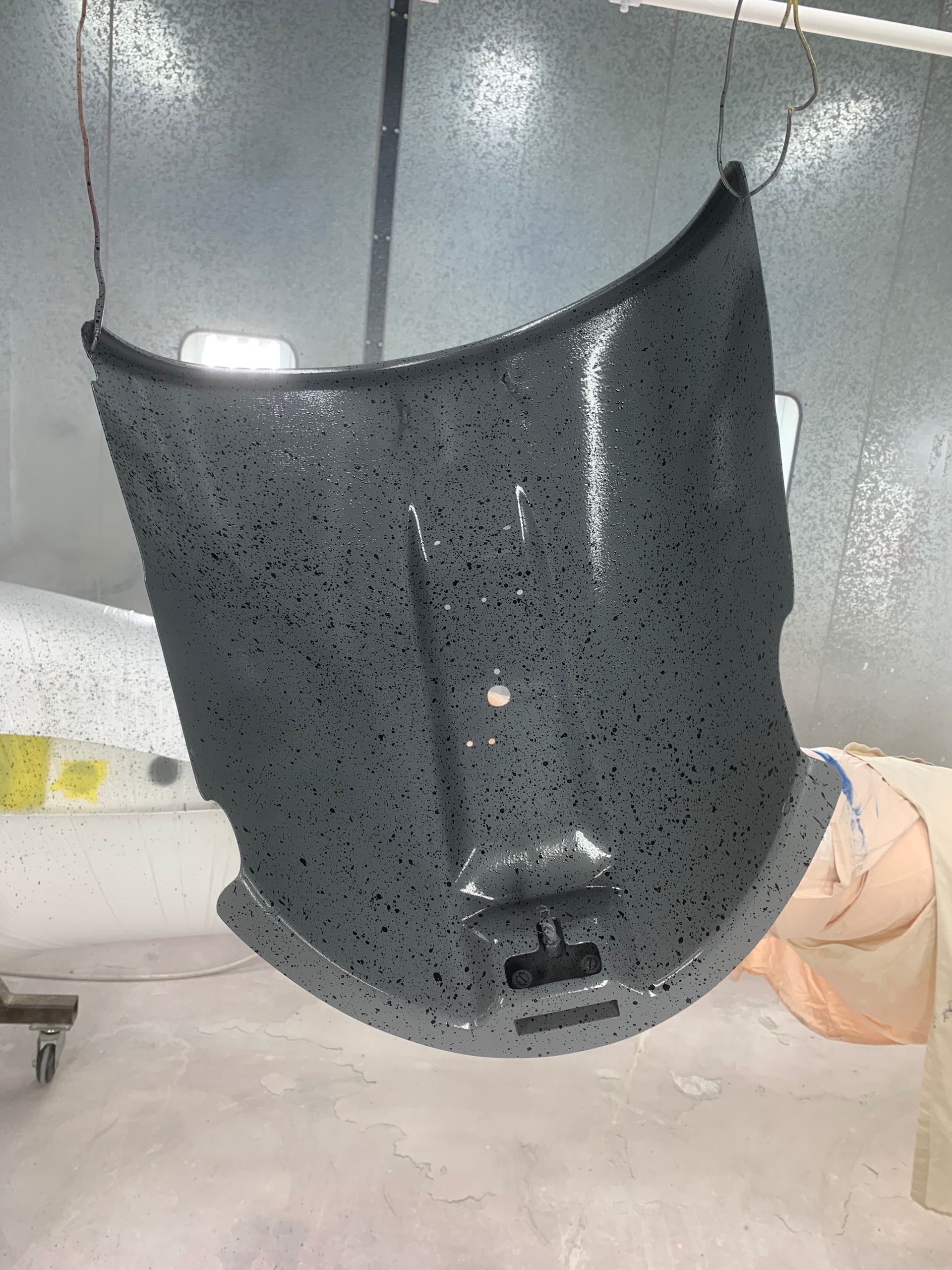 A piece of metal is hanging from a wire in a room.