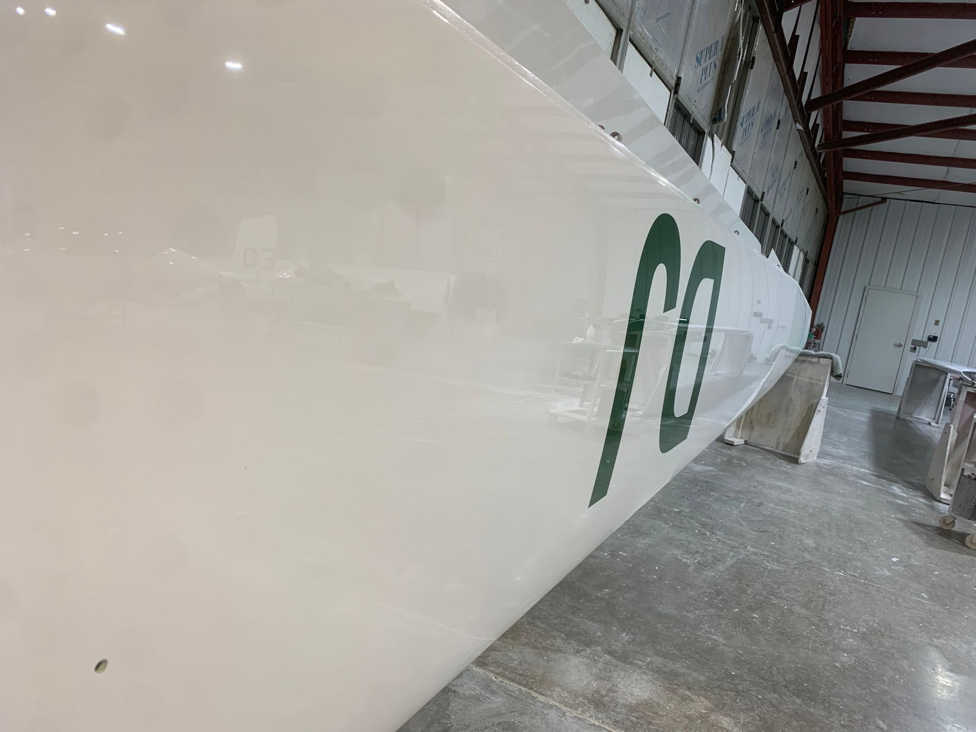 A white boat with a green letter m on the side