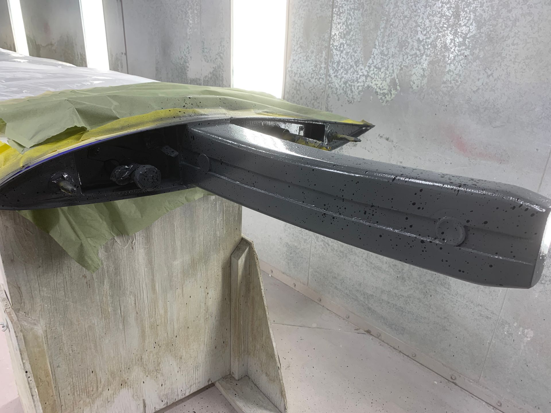 A car is being painted in a paint booth.