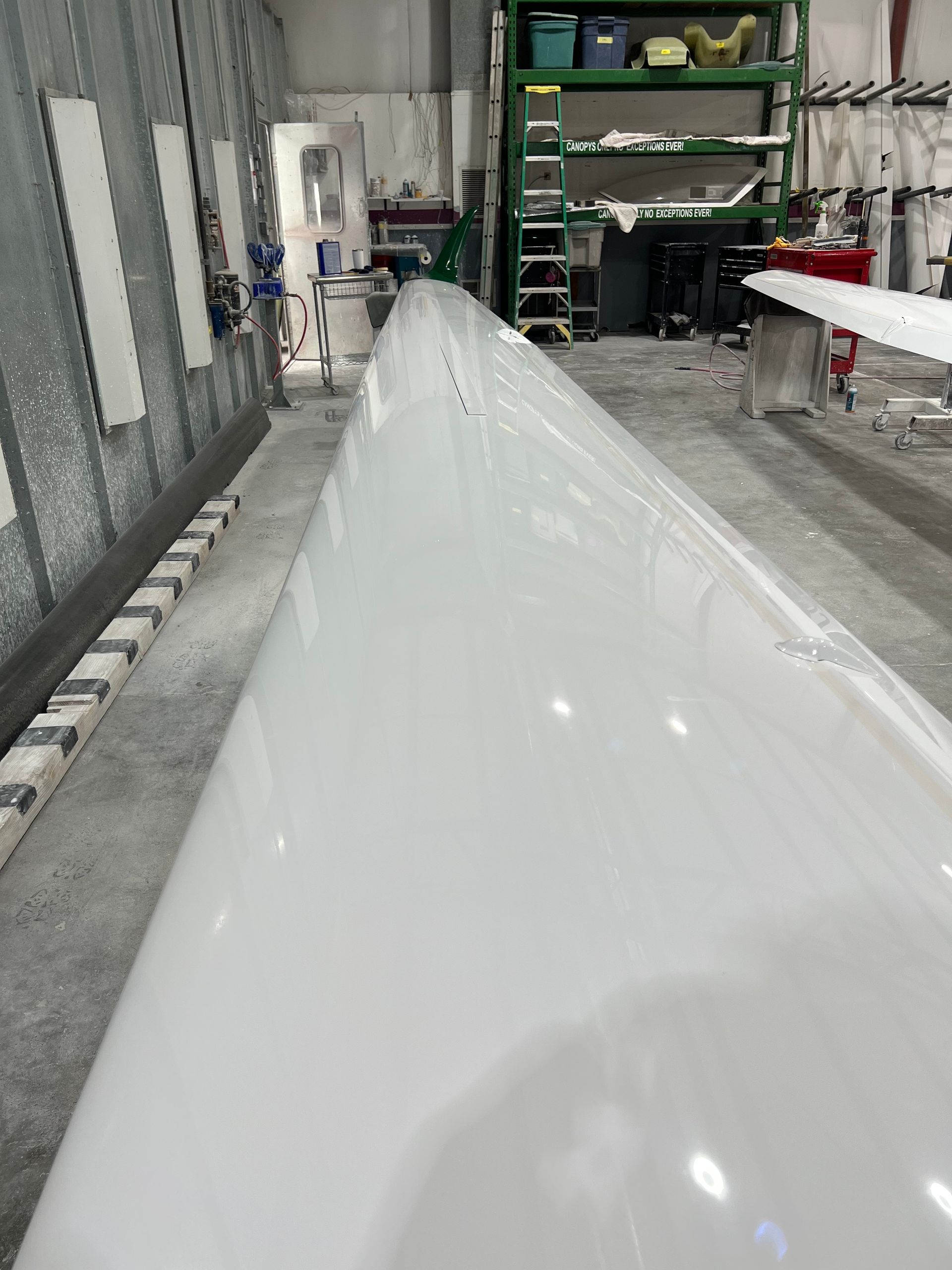 A large white object is sitting in a warehouse.