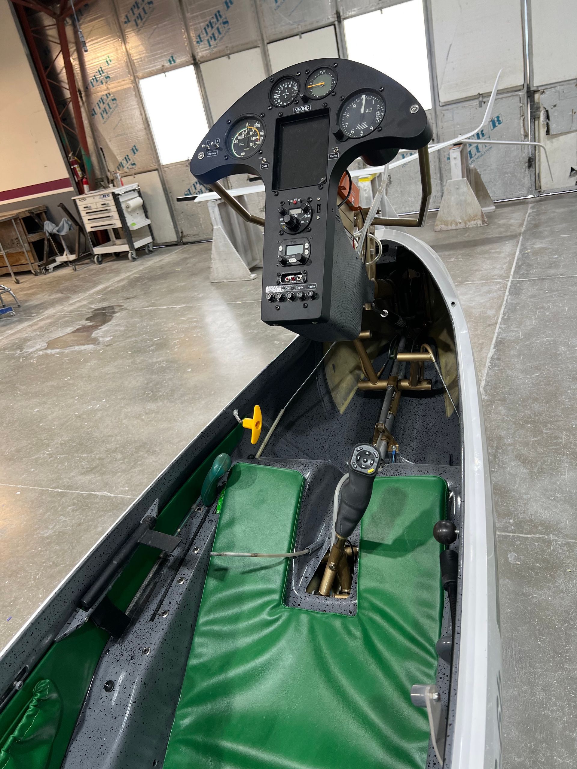 A cockpit of an airplane with a green seat