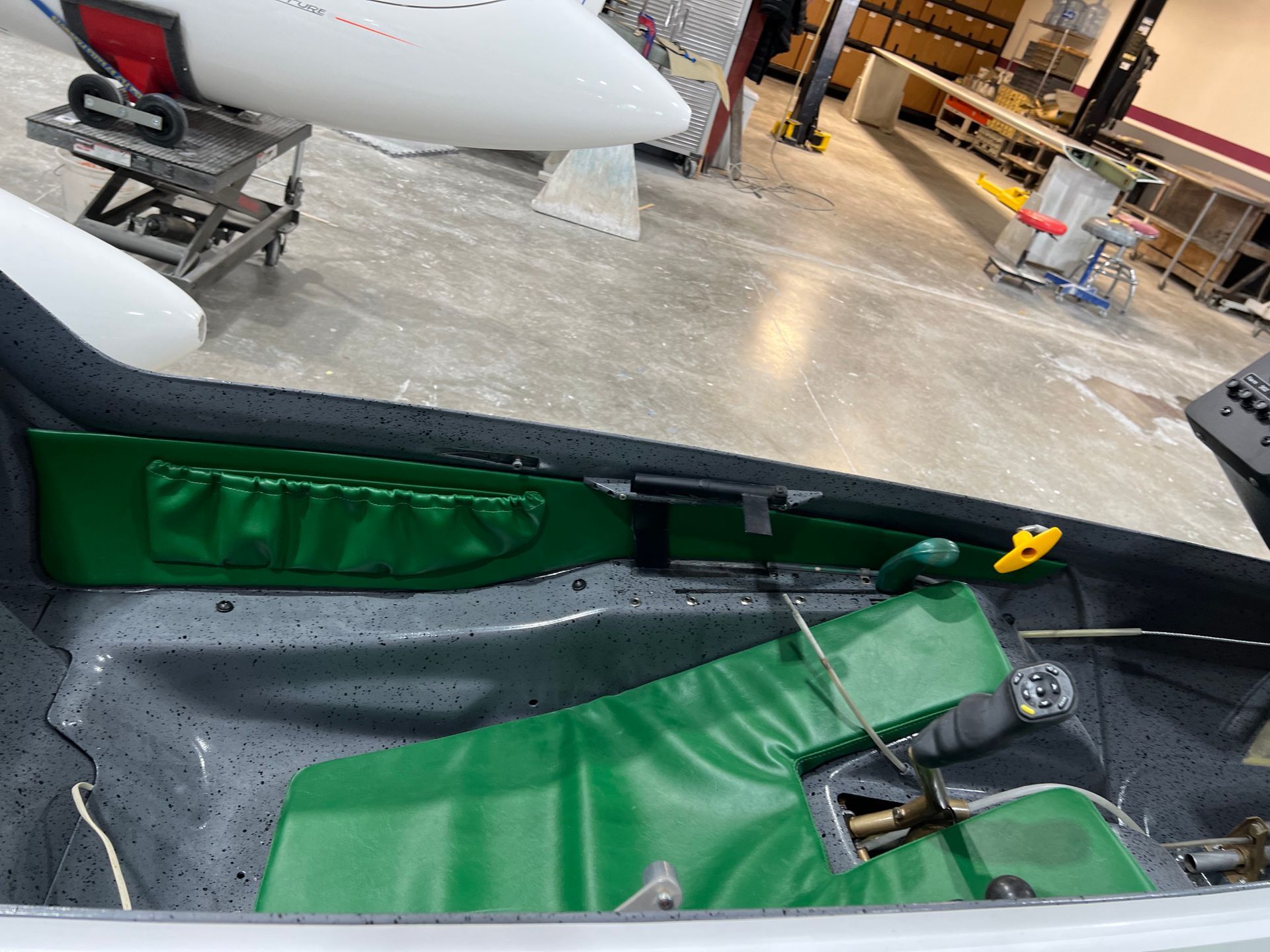 The inside of a plane with a green cushion on the seat.