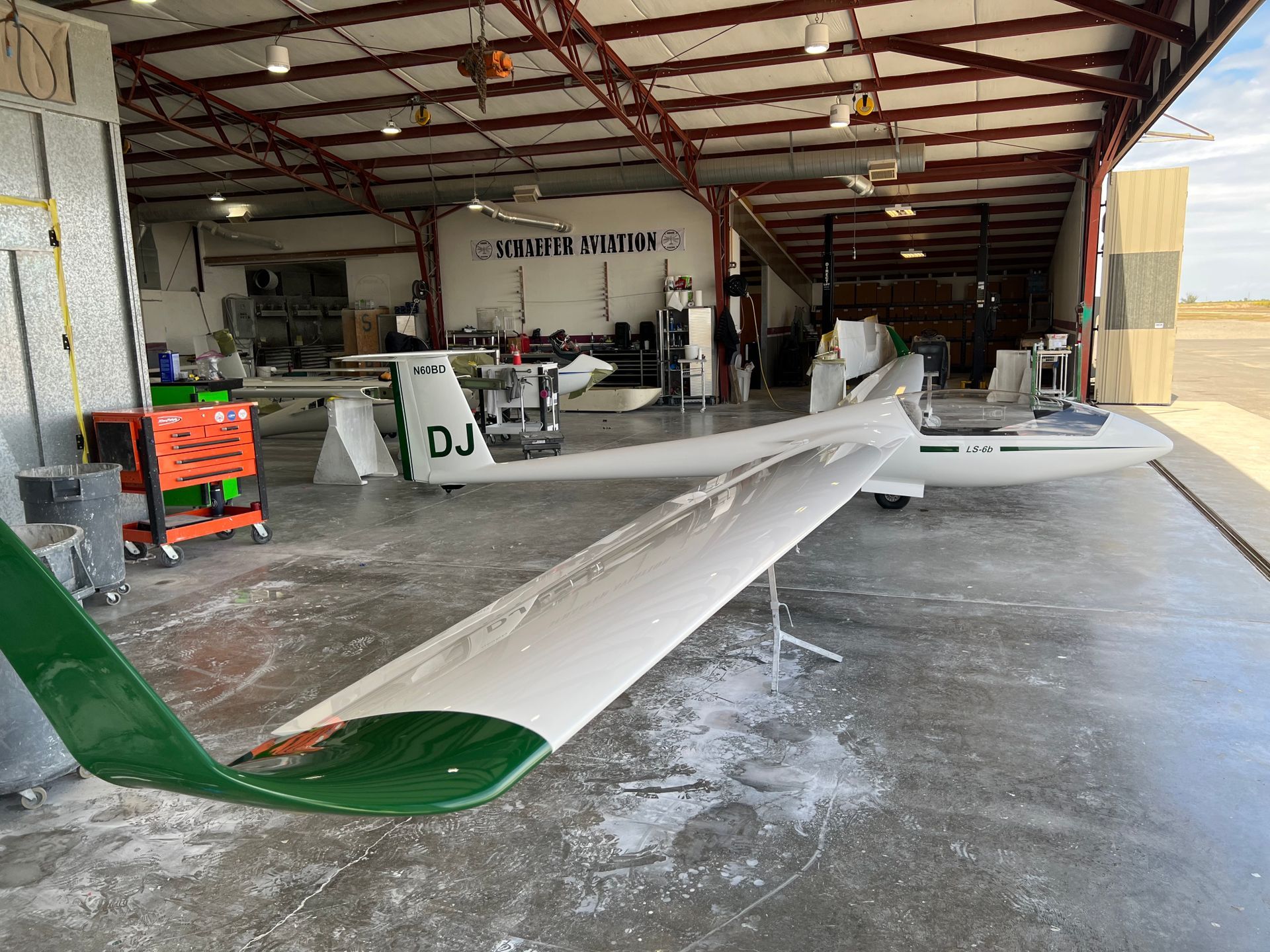 A plane with the letters dj on the side is parked in a hangar.