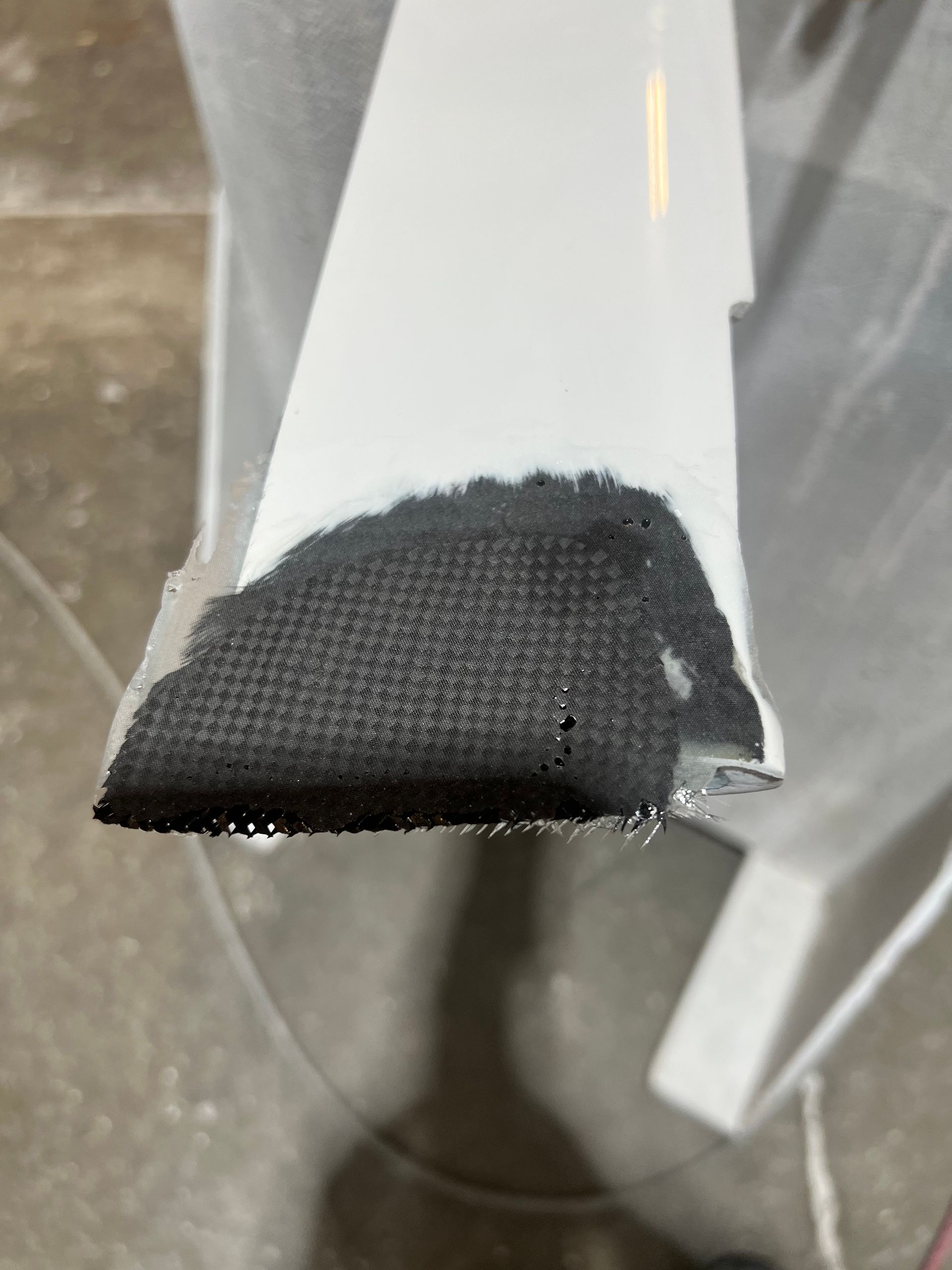 A close up of a piece of black fabric on a white surface.