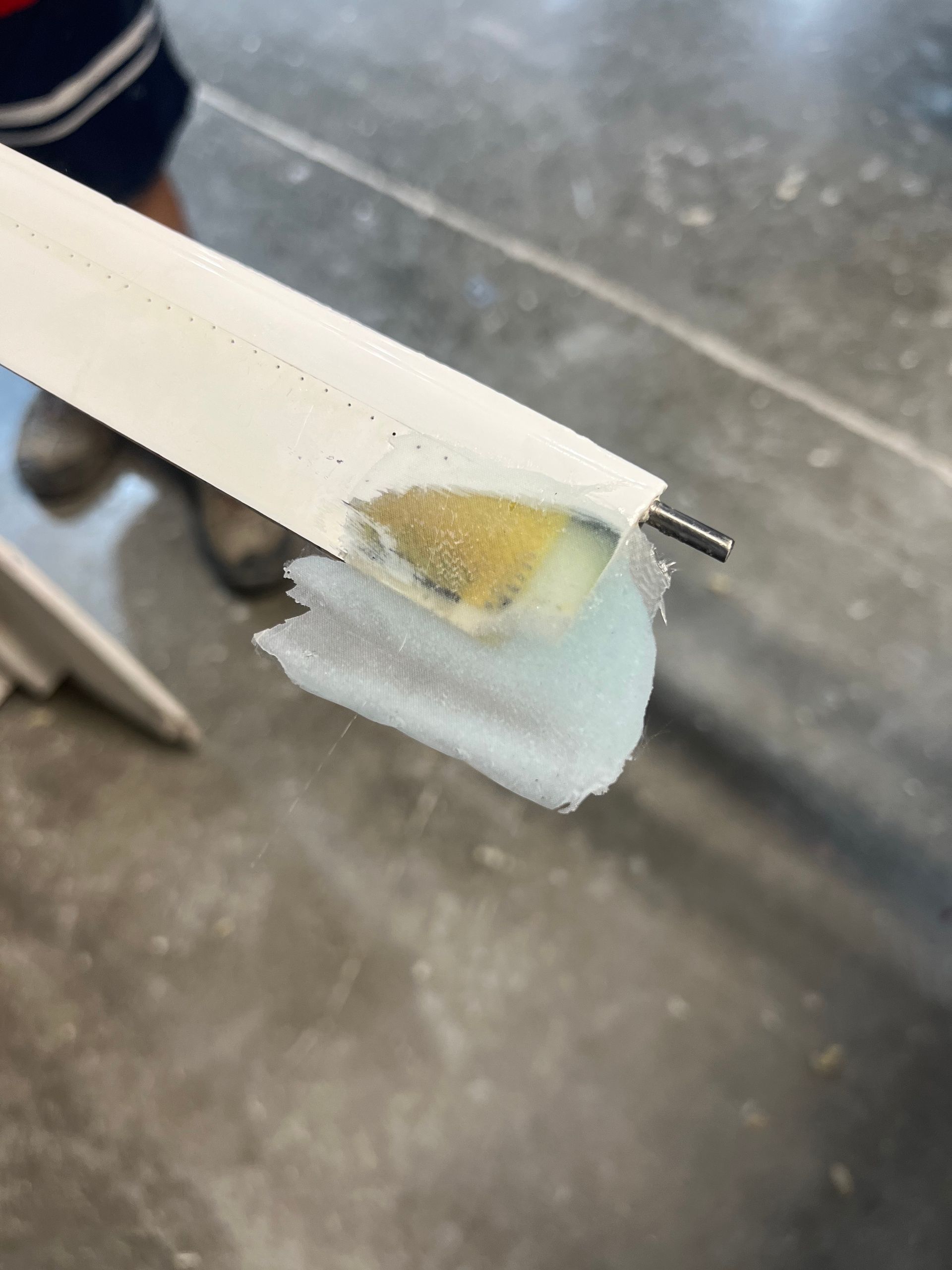 A person is holding a piece of paper with a brush on it.