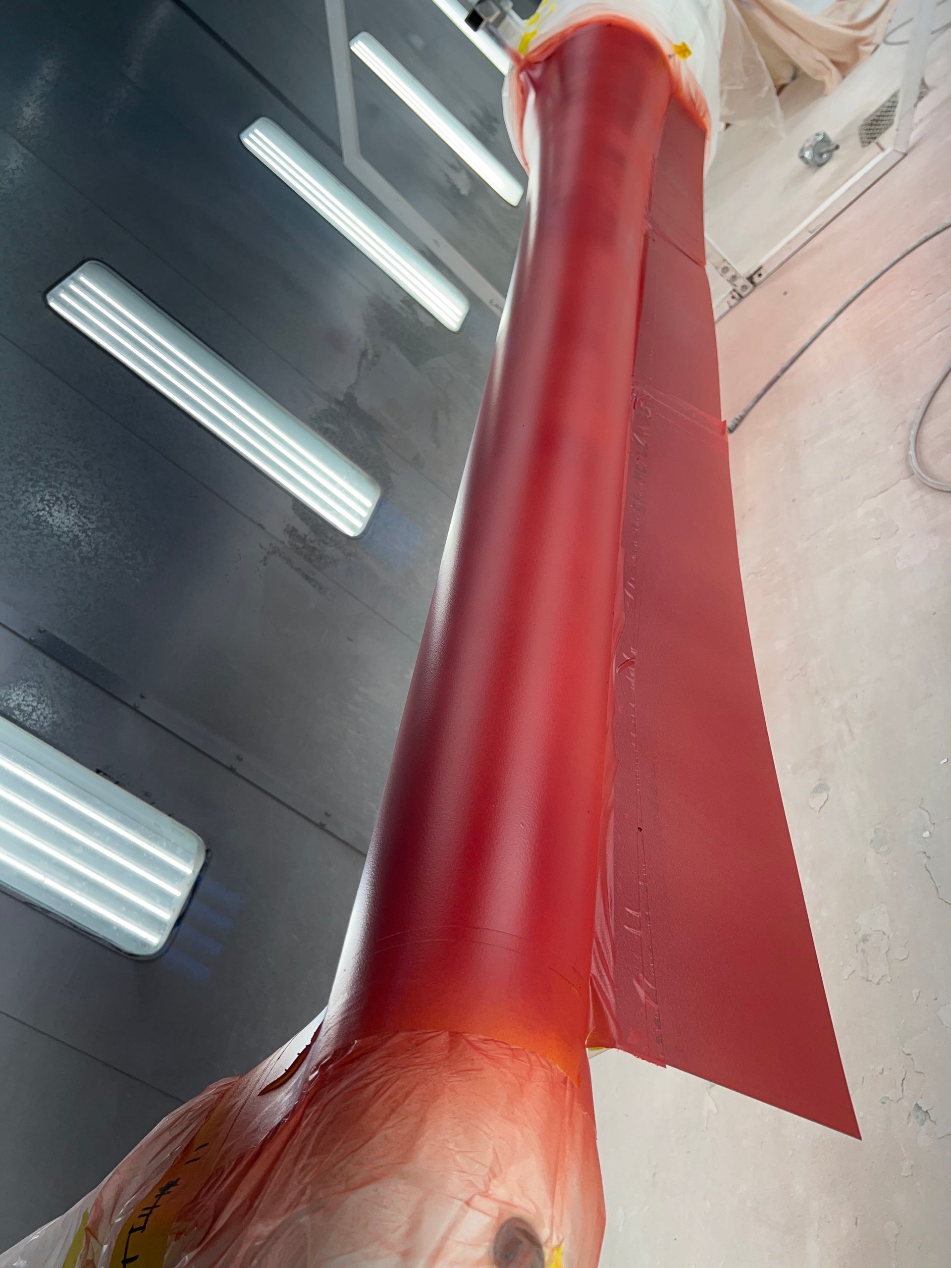 A red and white object is being painted in a room