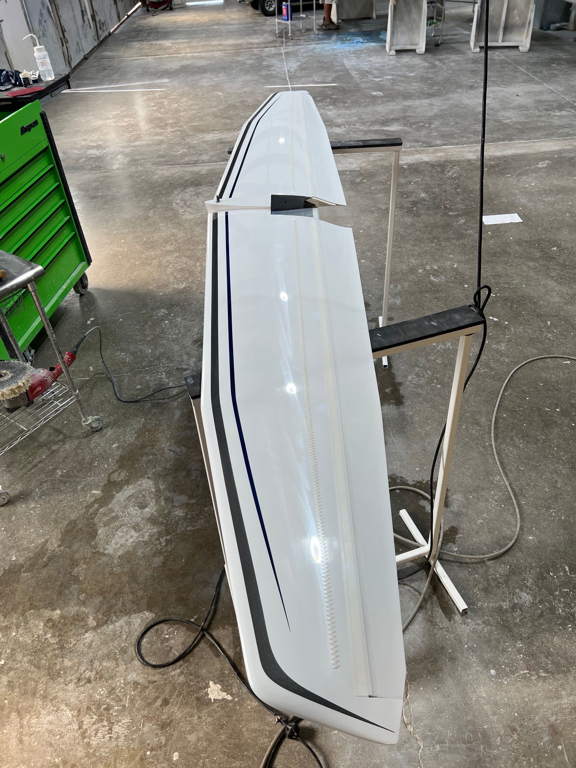 A wing is sitting on a stand in a warehouse.