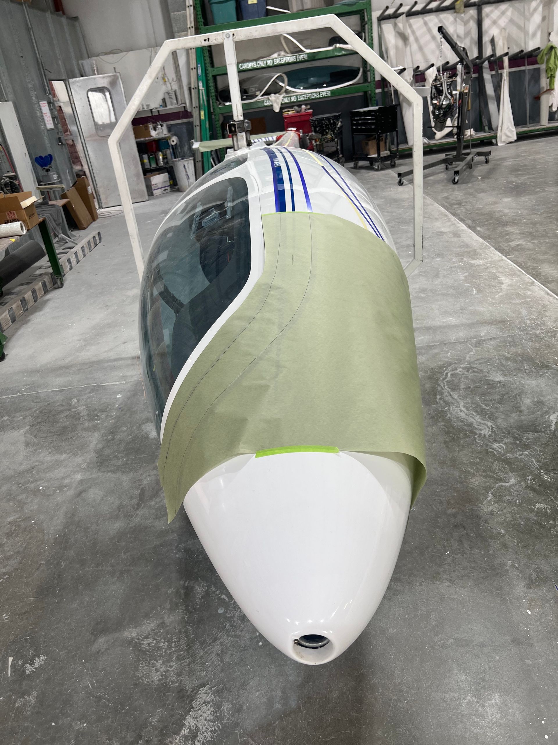 A white plane is sitting on the ground in a garage.