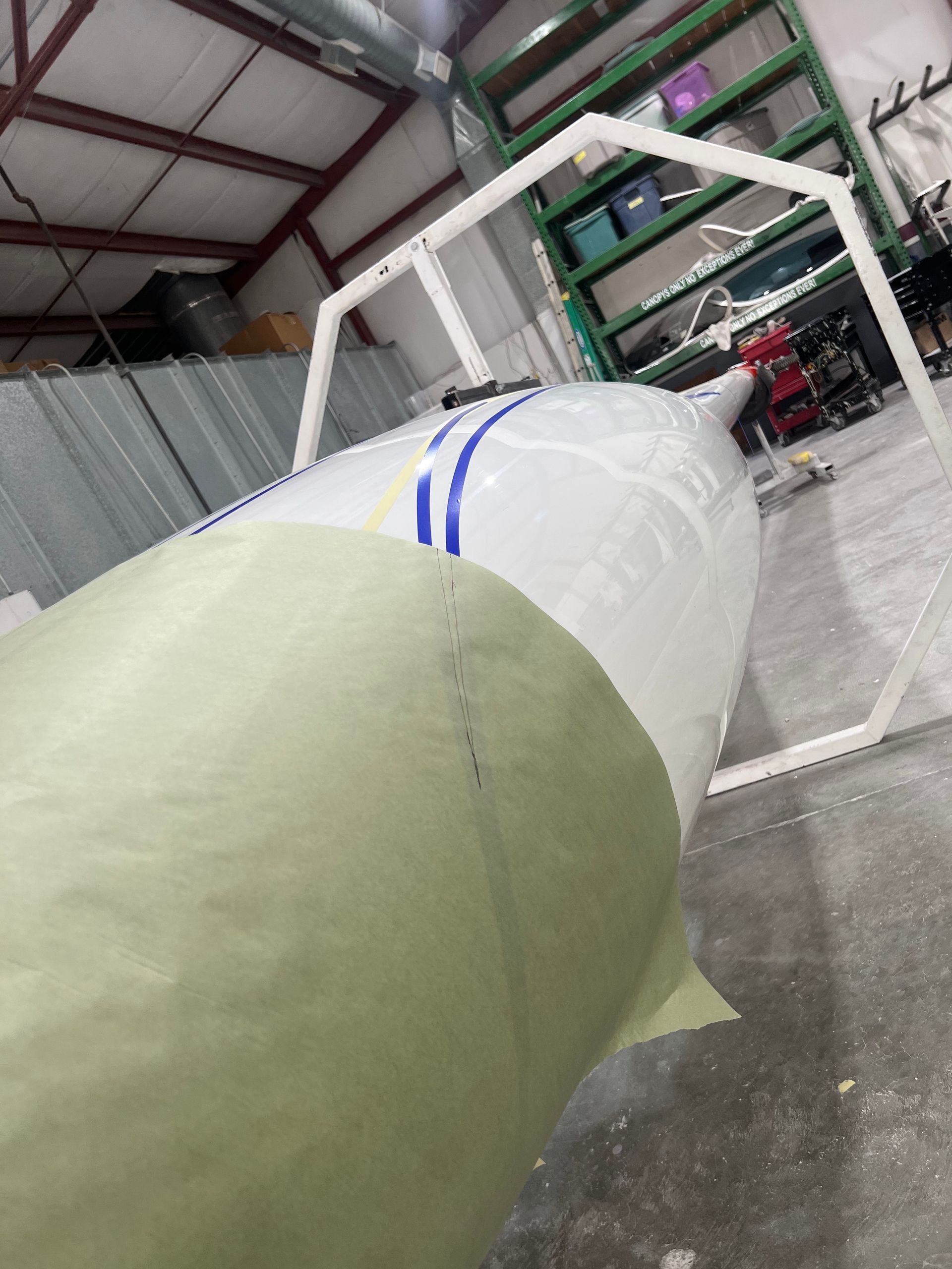 A large white object is sitting on a concrete floor in a warehouse.