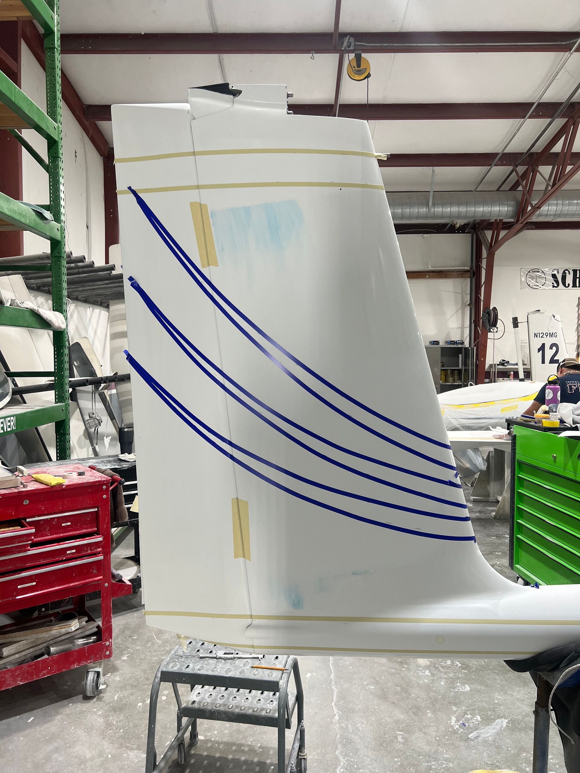 A white plane wing with blue stripes on it