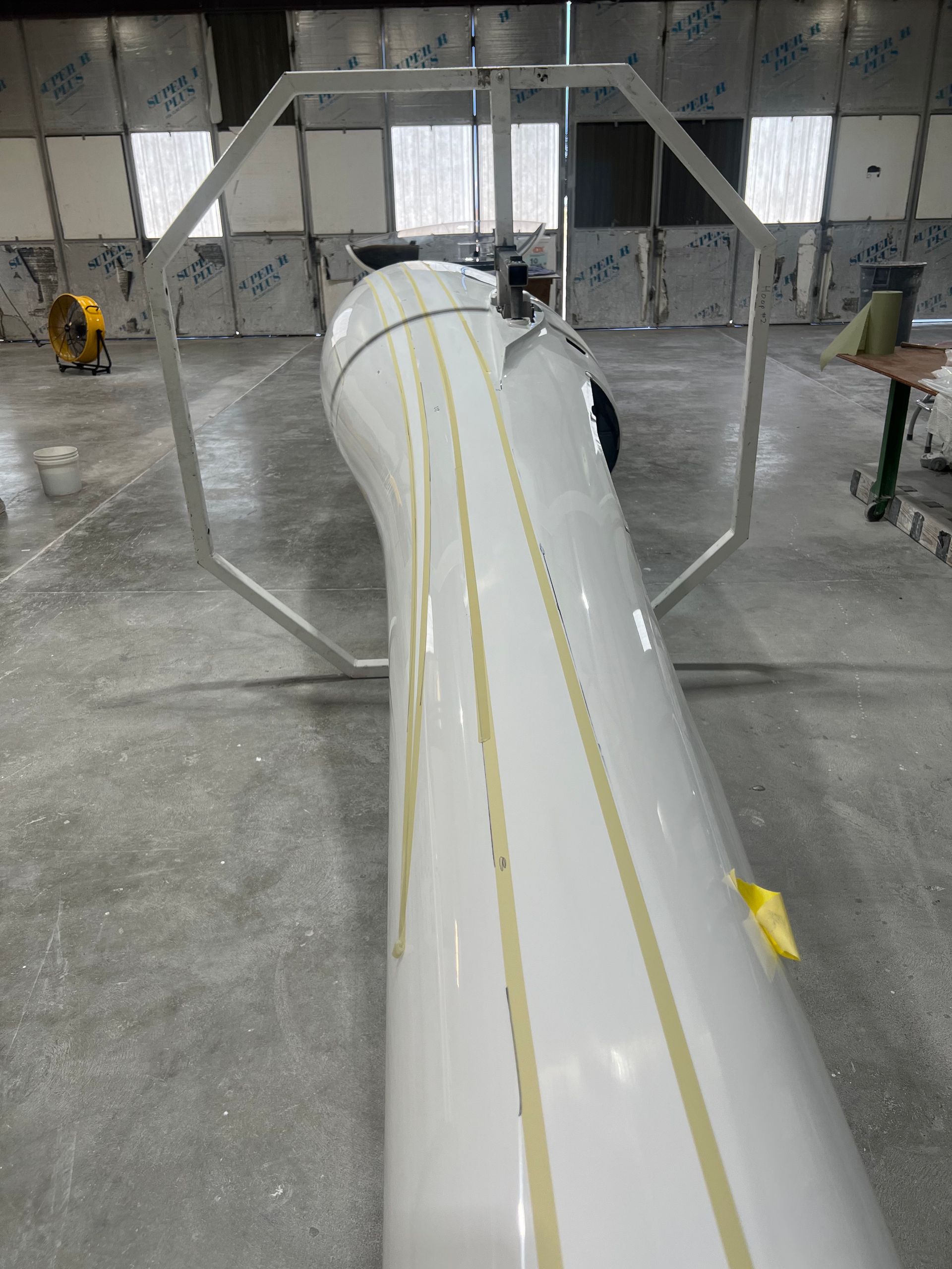 A large white pipe is sitting in a warehouse.
