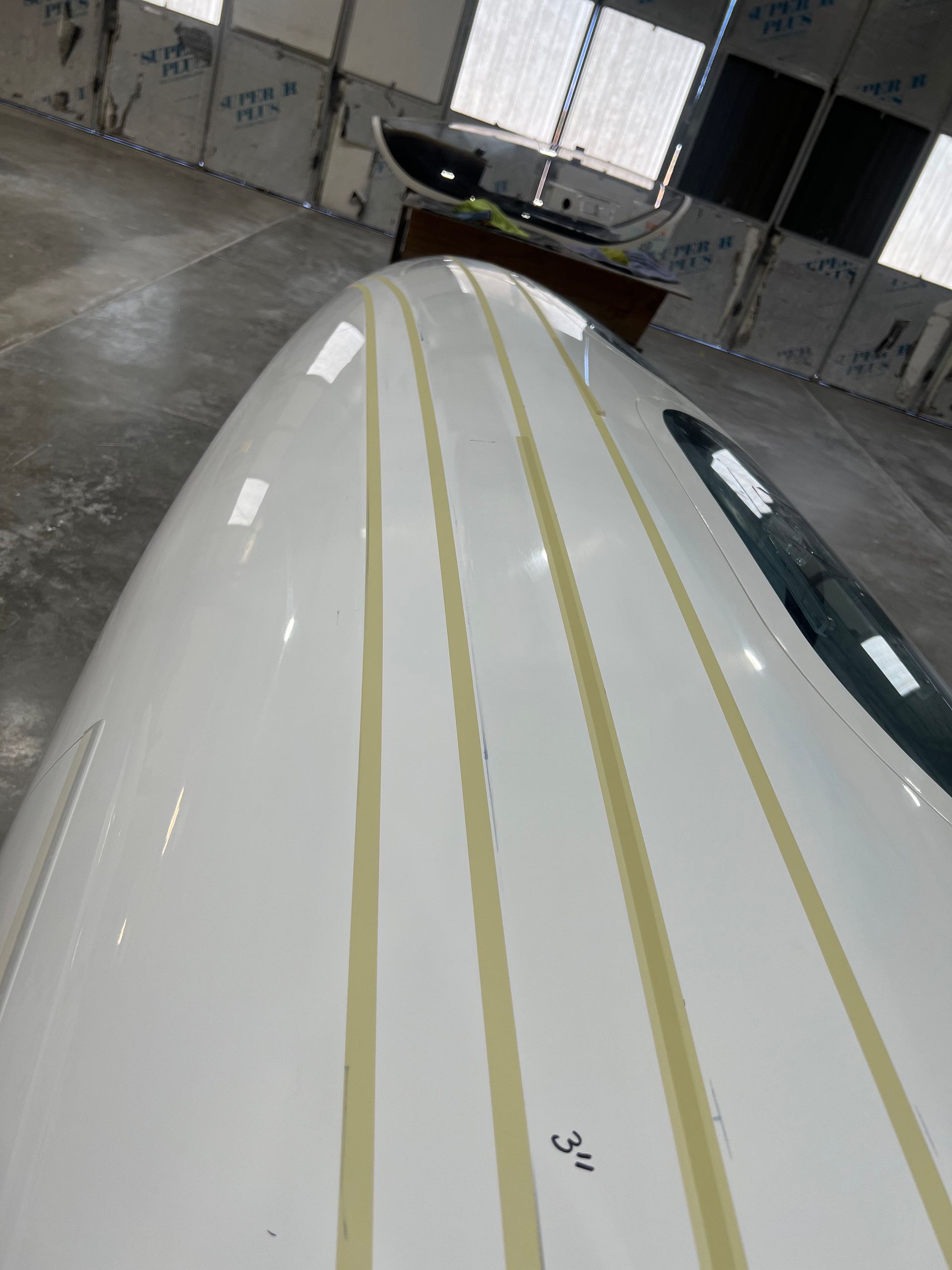 A close up of a white boat with yellow stripes on it