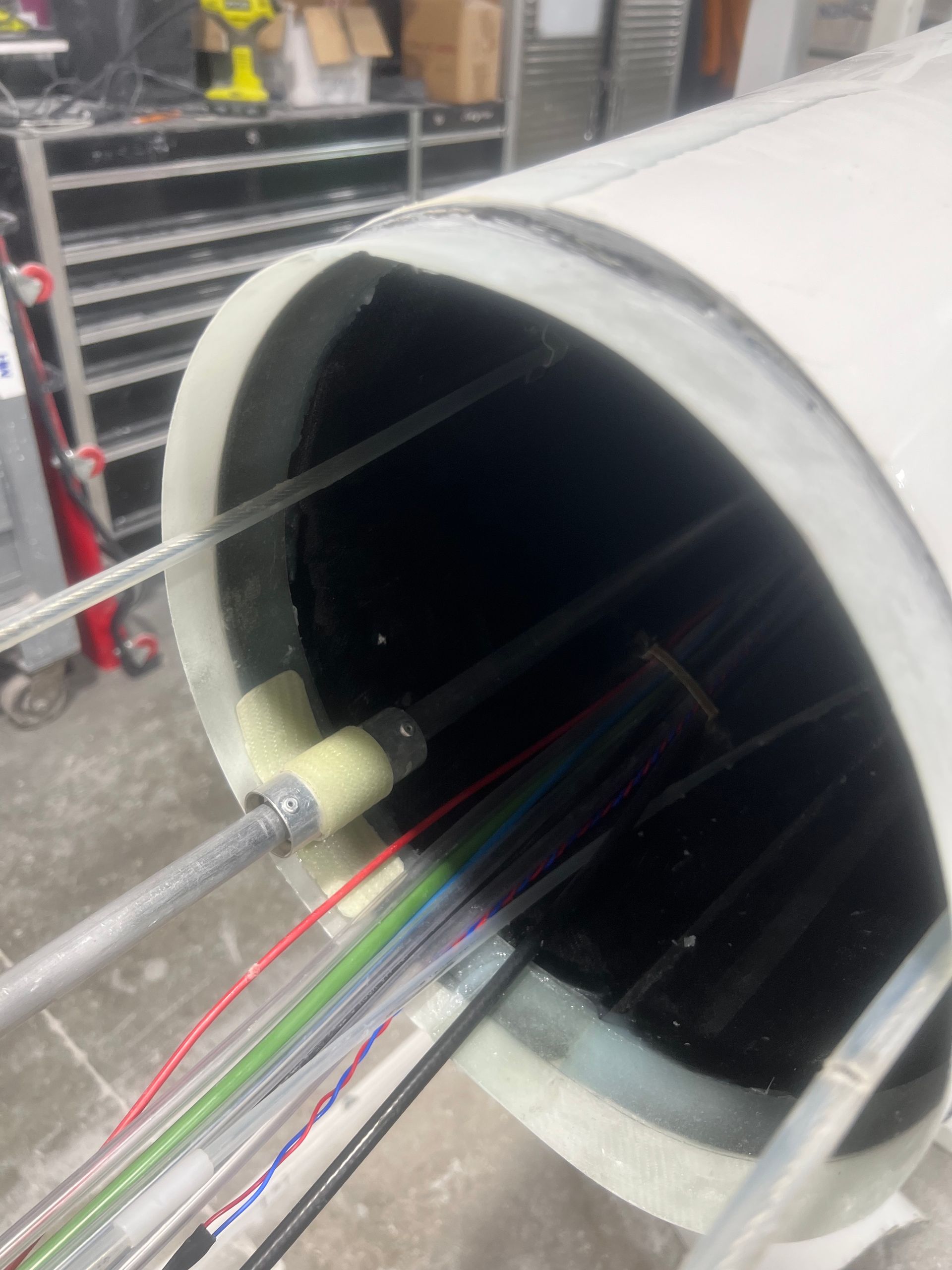 A white pipe with a bunch of wires coming out of it