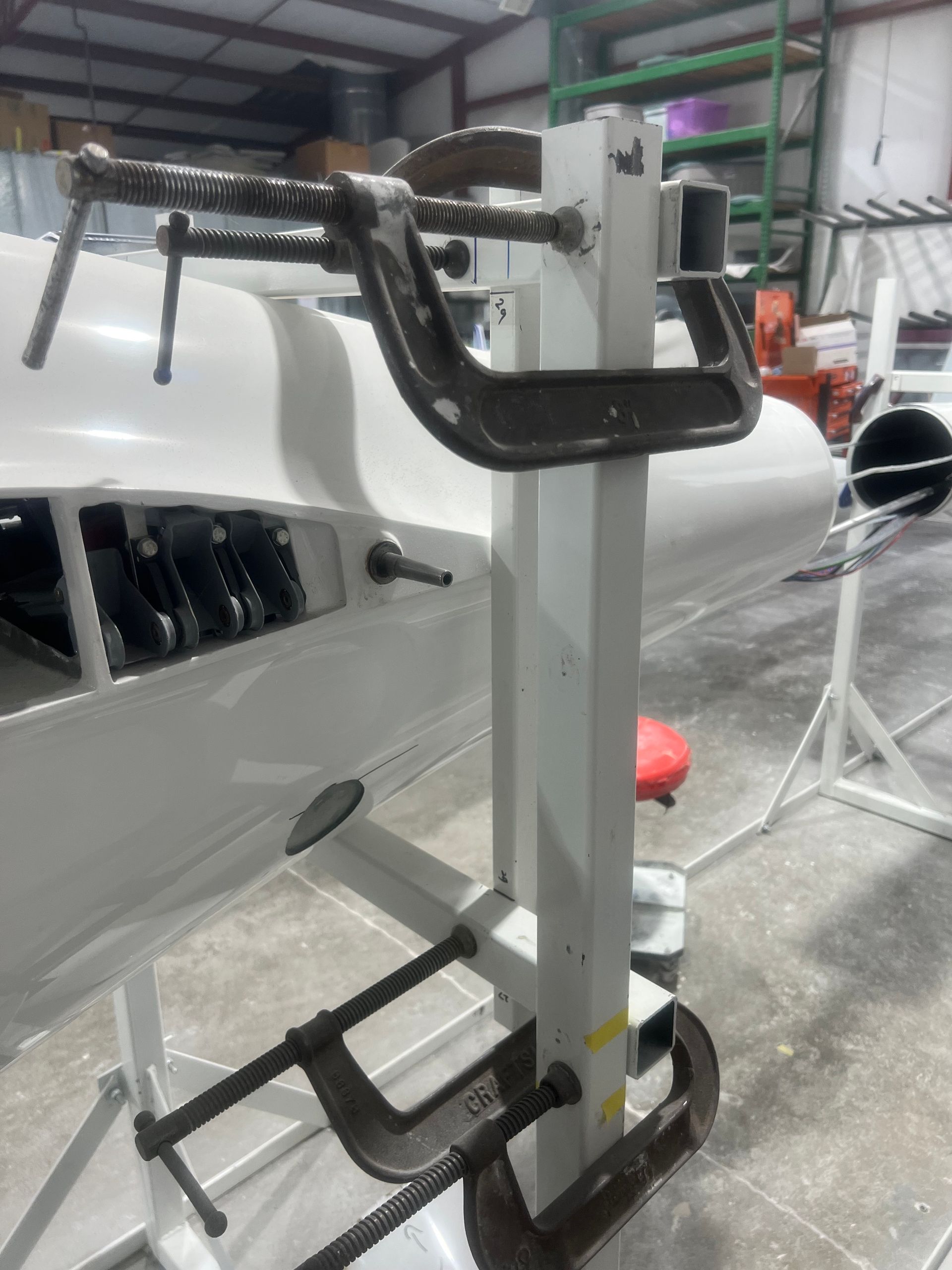 A machine is sitting in a warehouse next to a boat