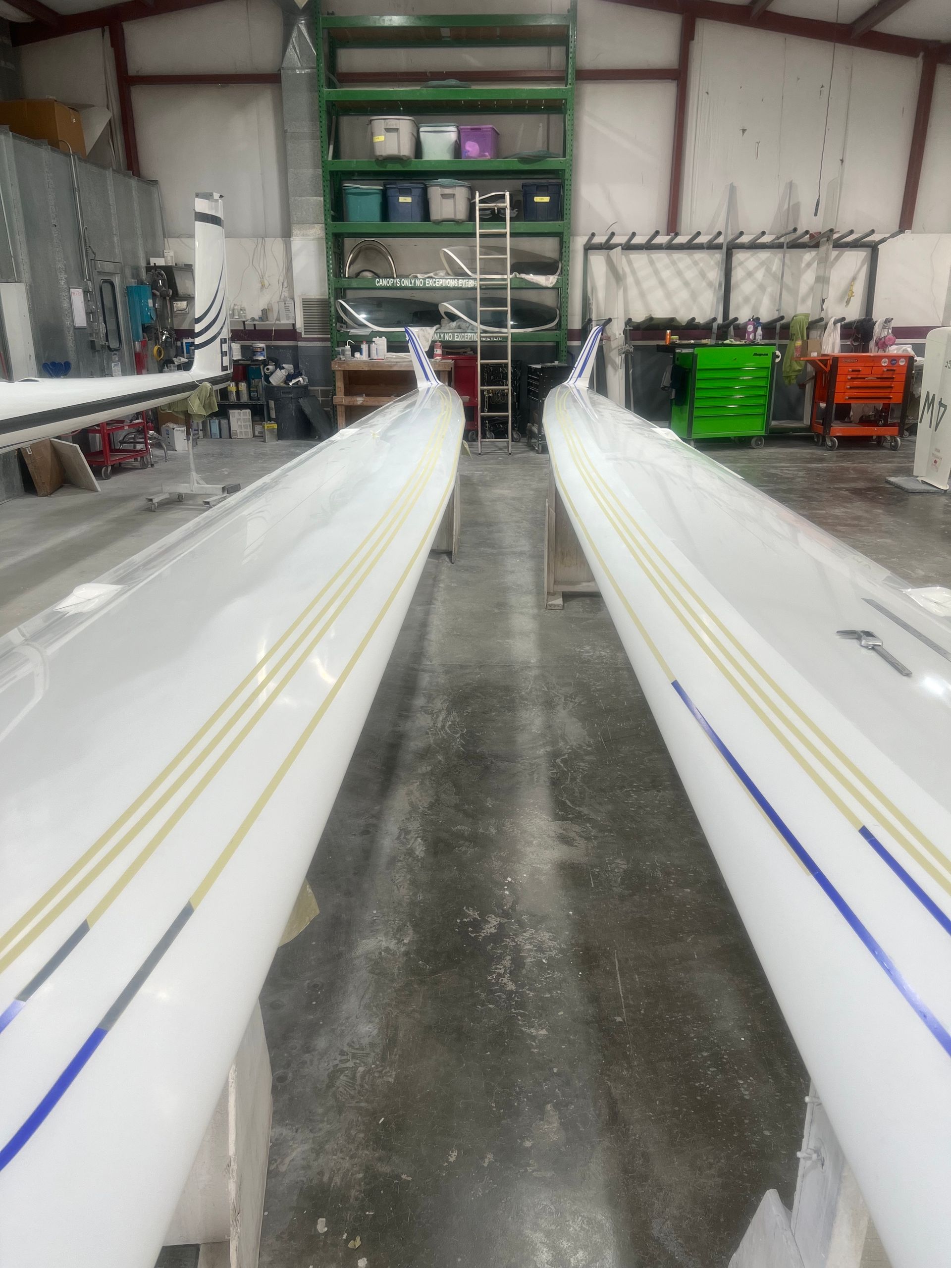 Two white tubes with blue and yellow stripes are in a warehouse