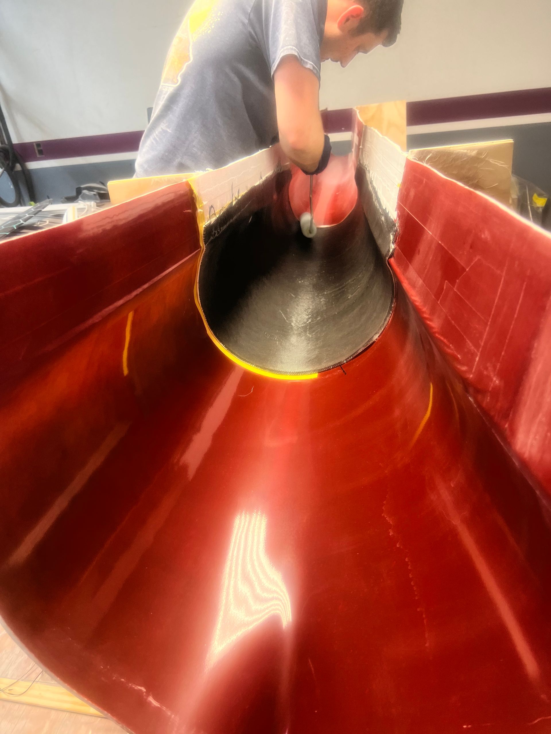 A man is pouring concrete into a red pipe.