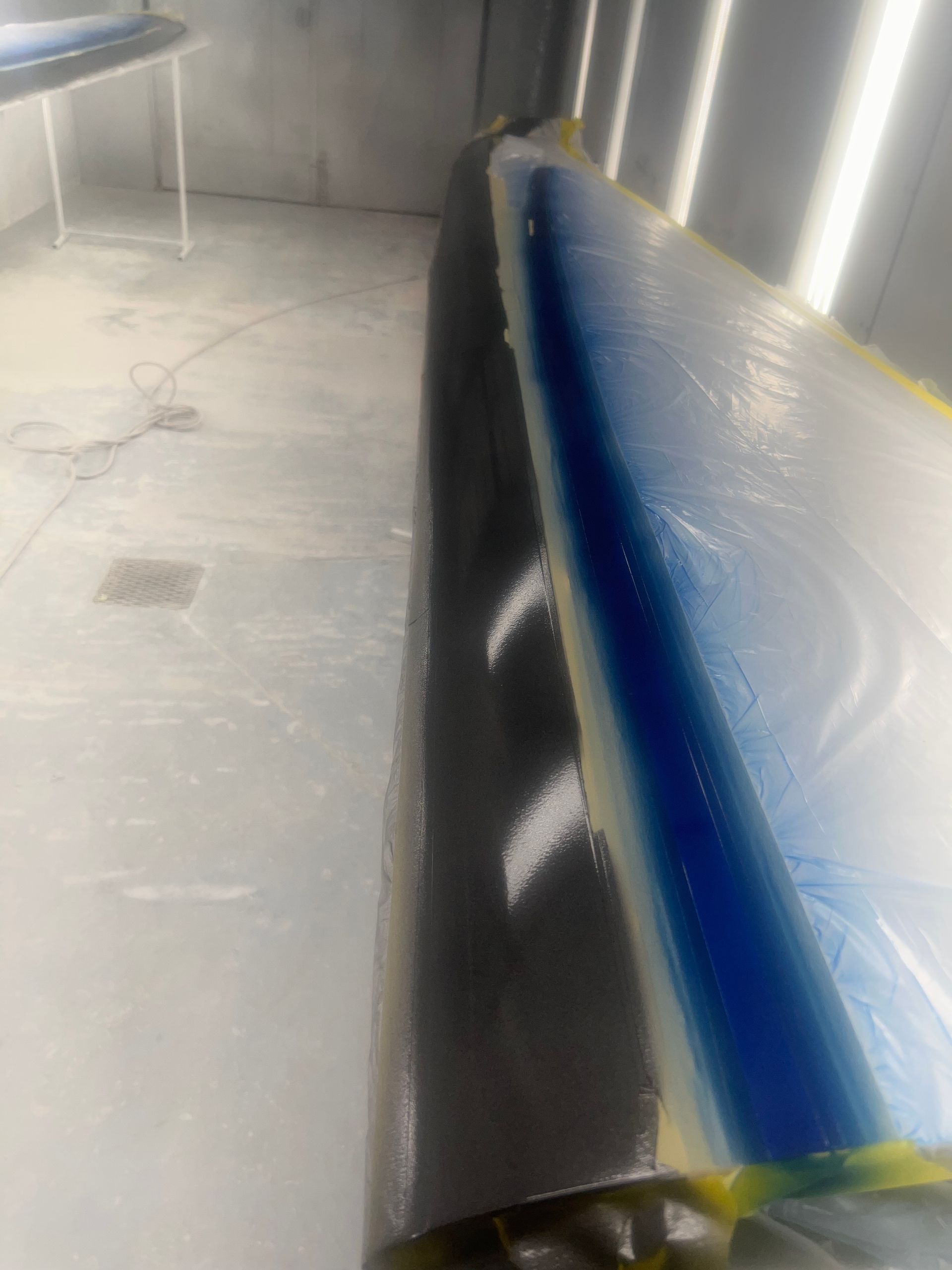 A car is being painted in a paint booth.