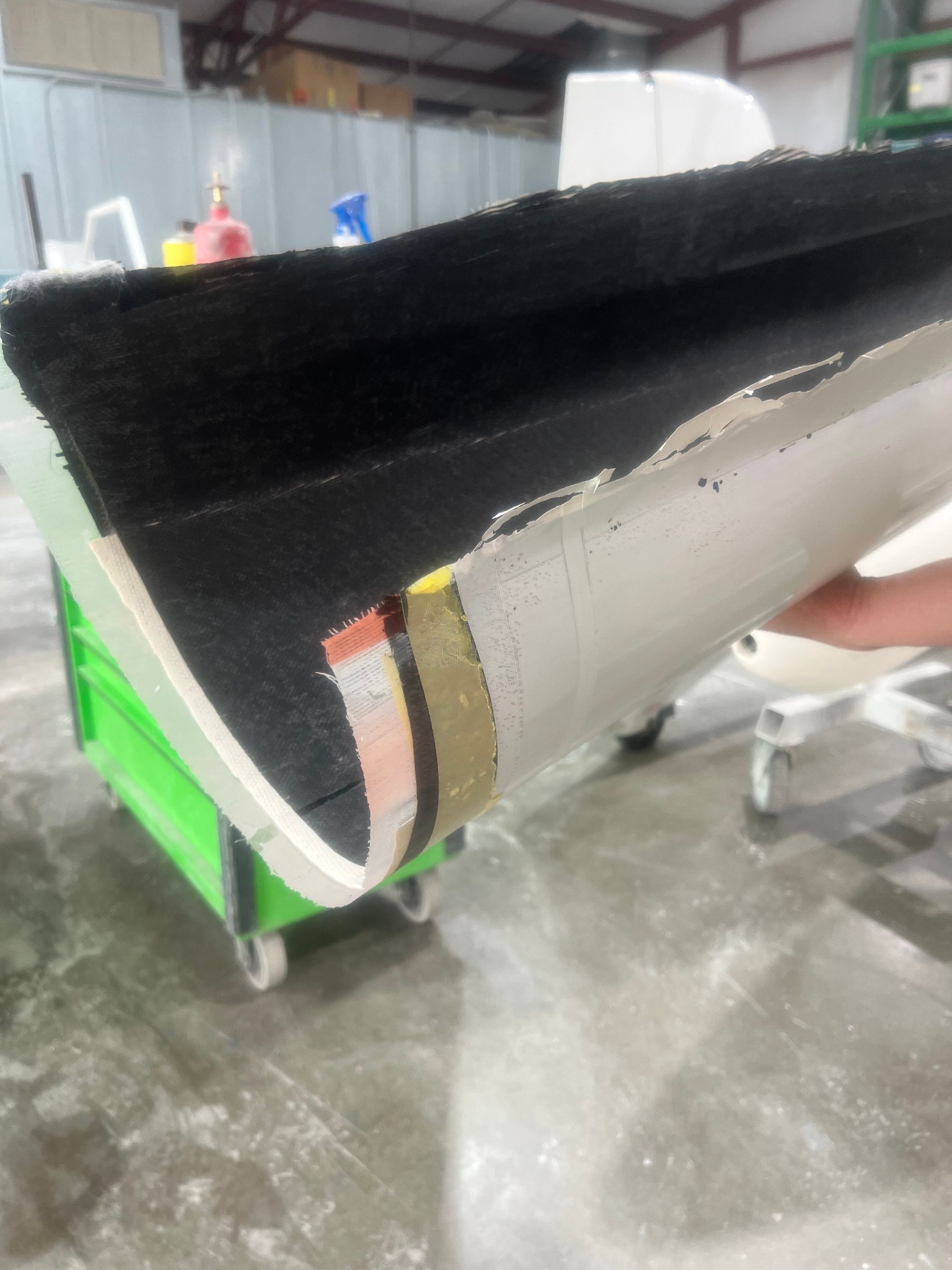 A person is holding a piece of carpet in their hand.