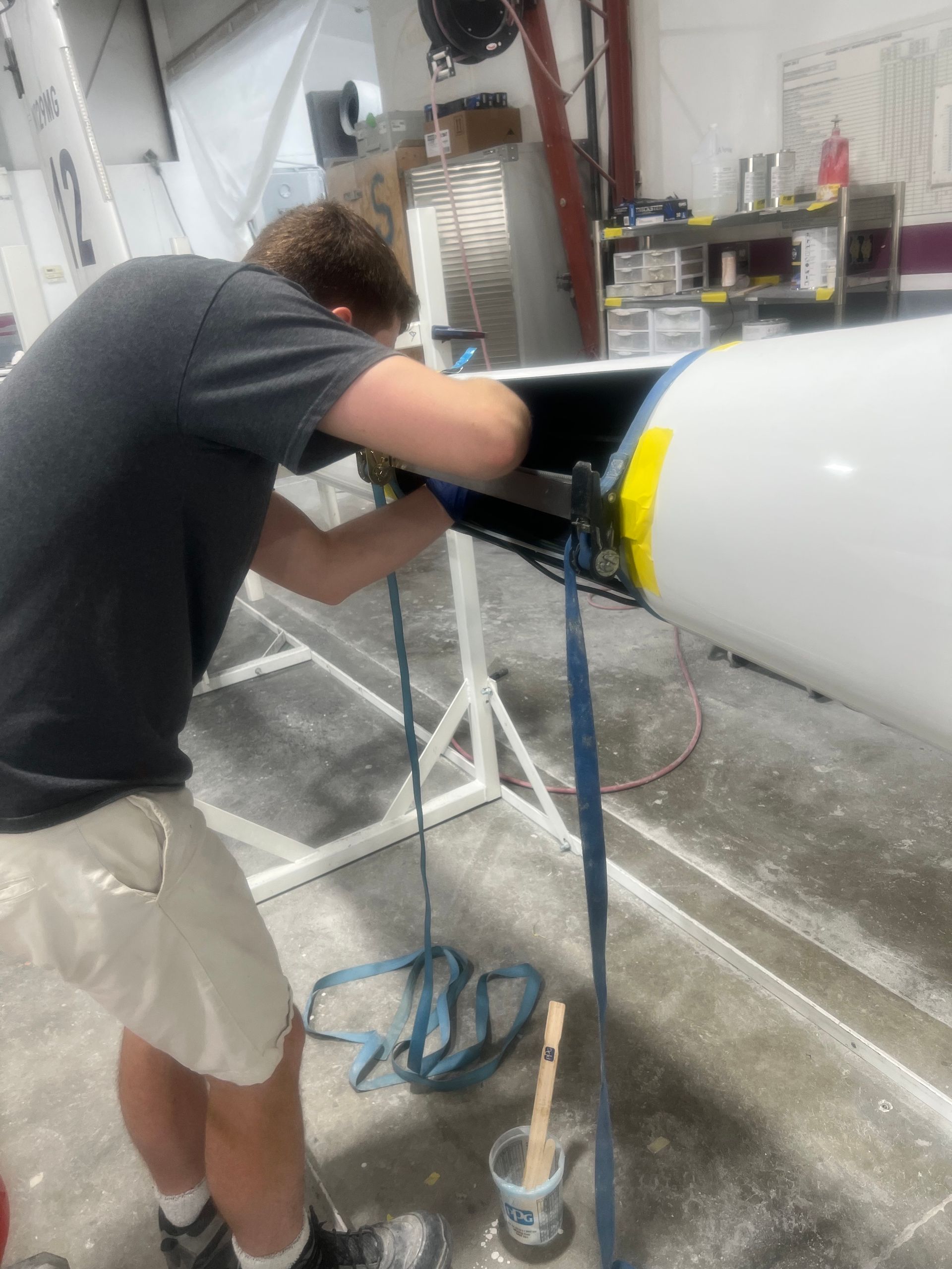 A man is working on a boat in a garage