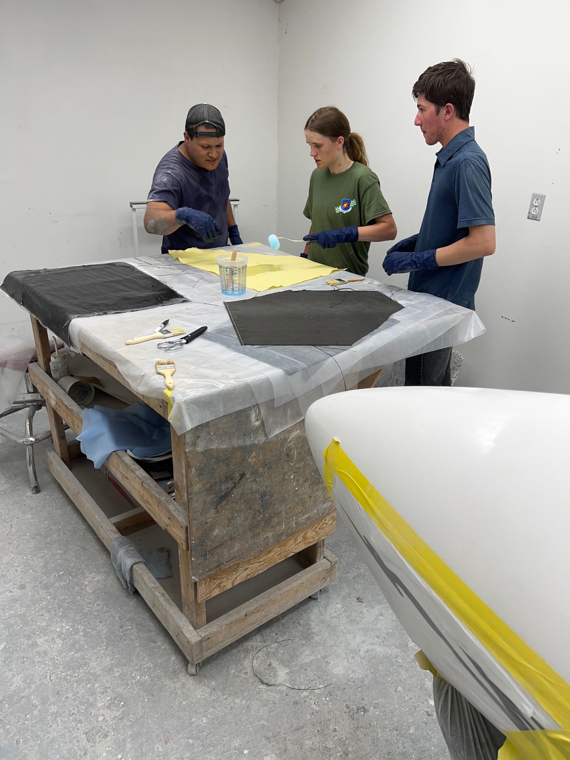 A group of people are working on a table in a room