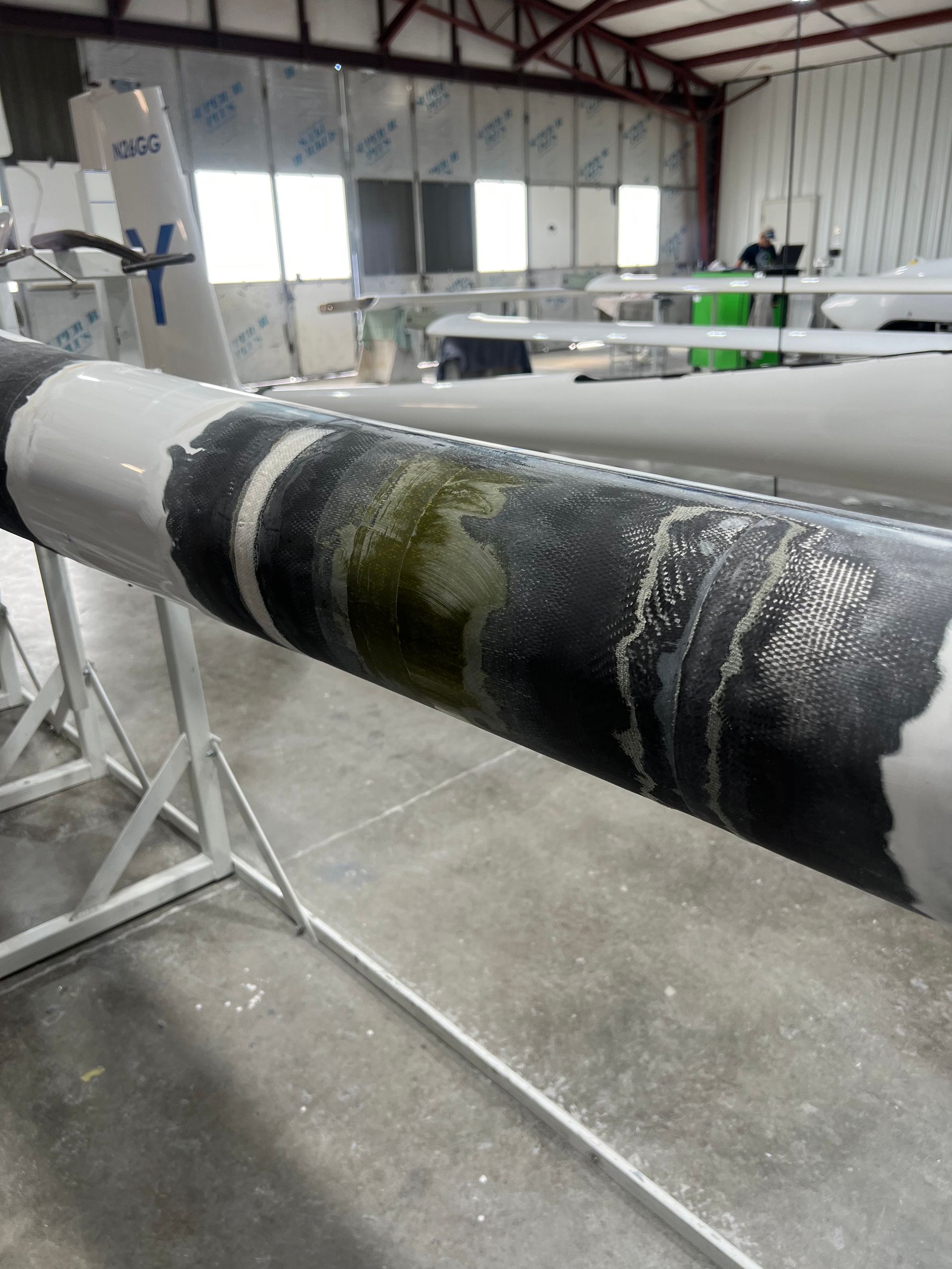 A large pipe is sitting on a stand in a warehouse.