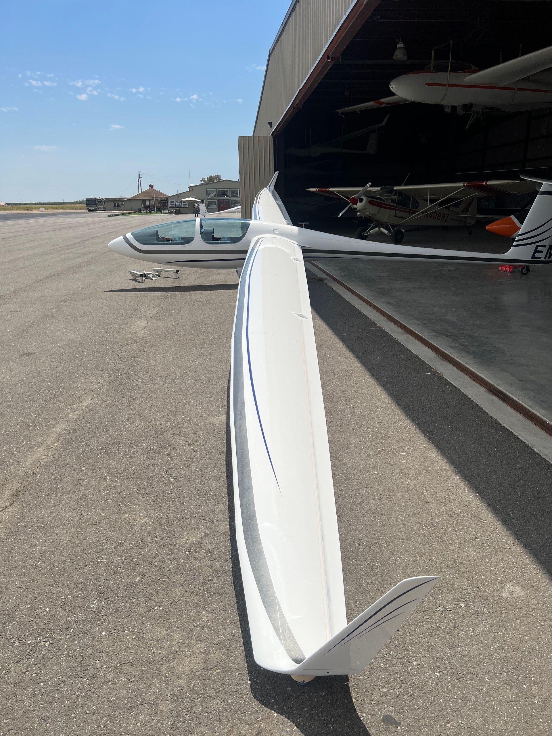 A plane is parked in a hangar with the door open