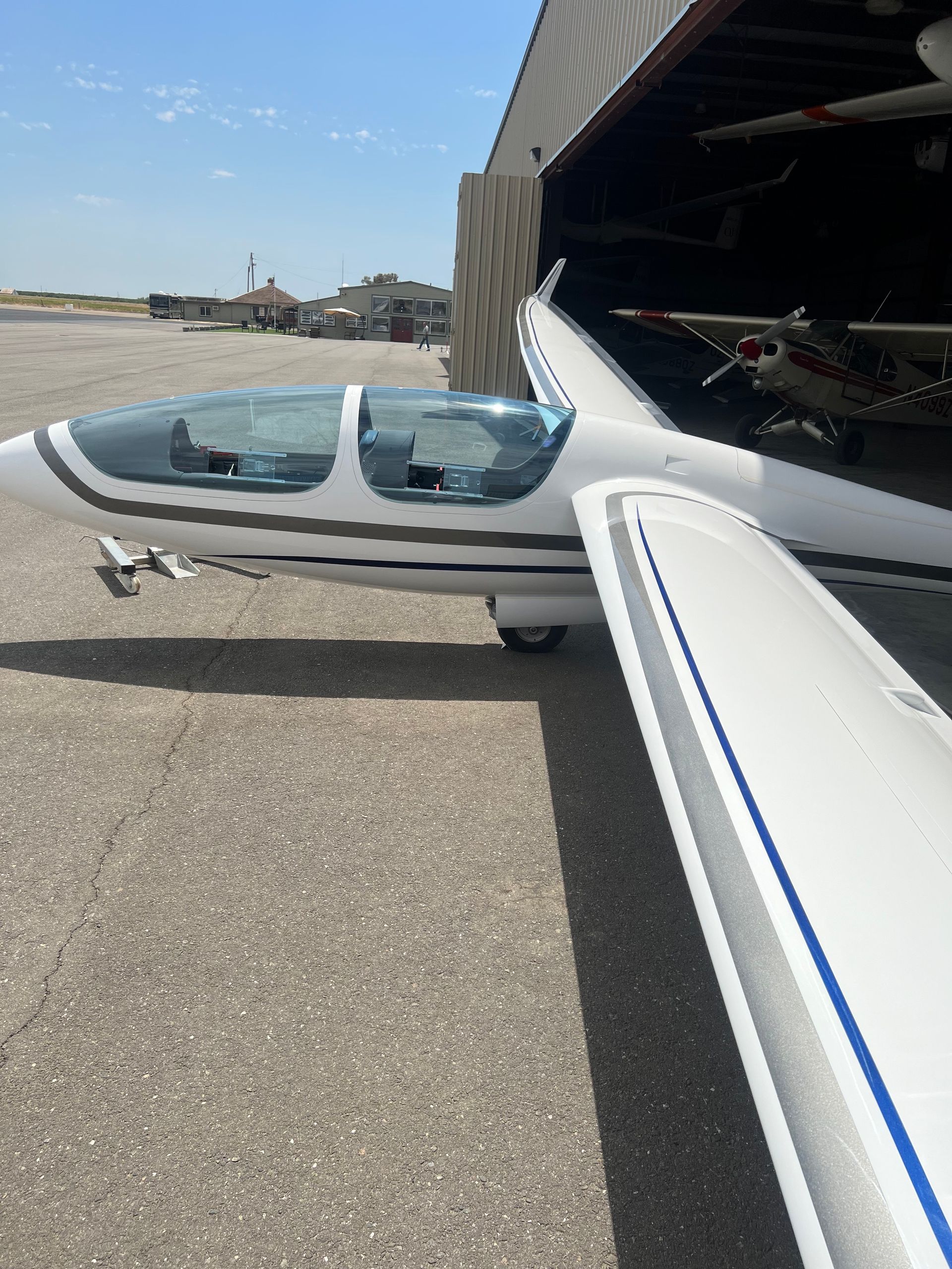 A small plane is parked in front of a hangar