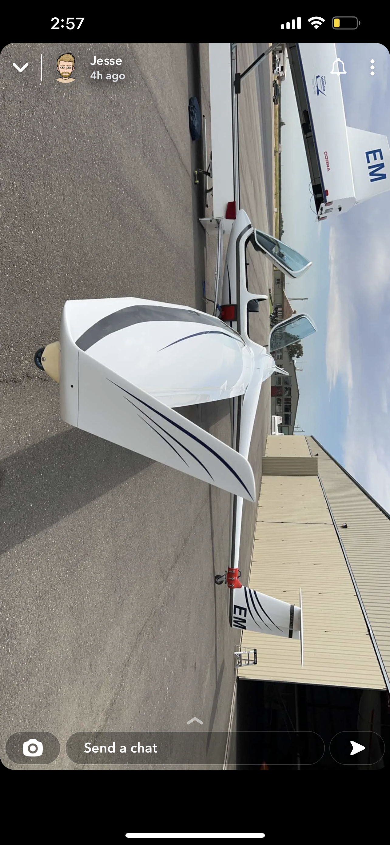 A plane is parked on the side of the road next to a building.