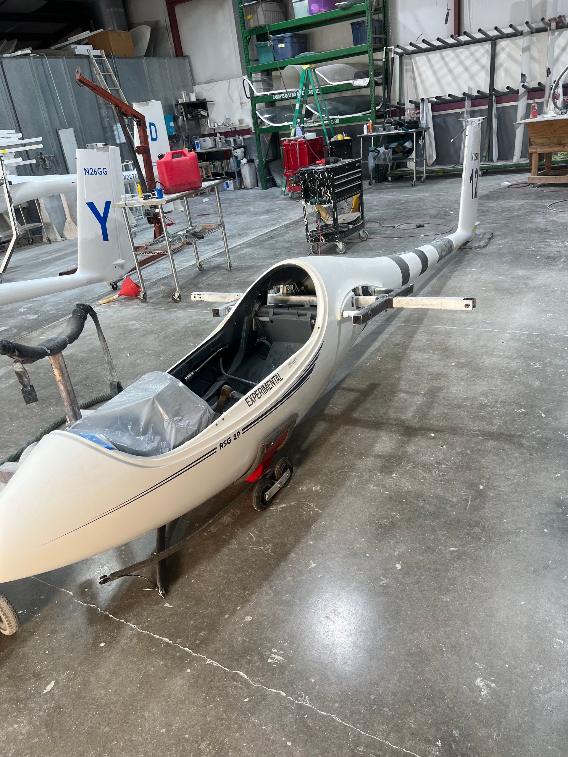 A small white plane is sitting in a warehouse.