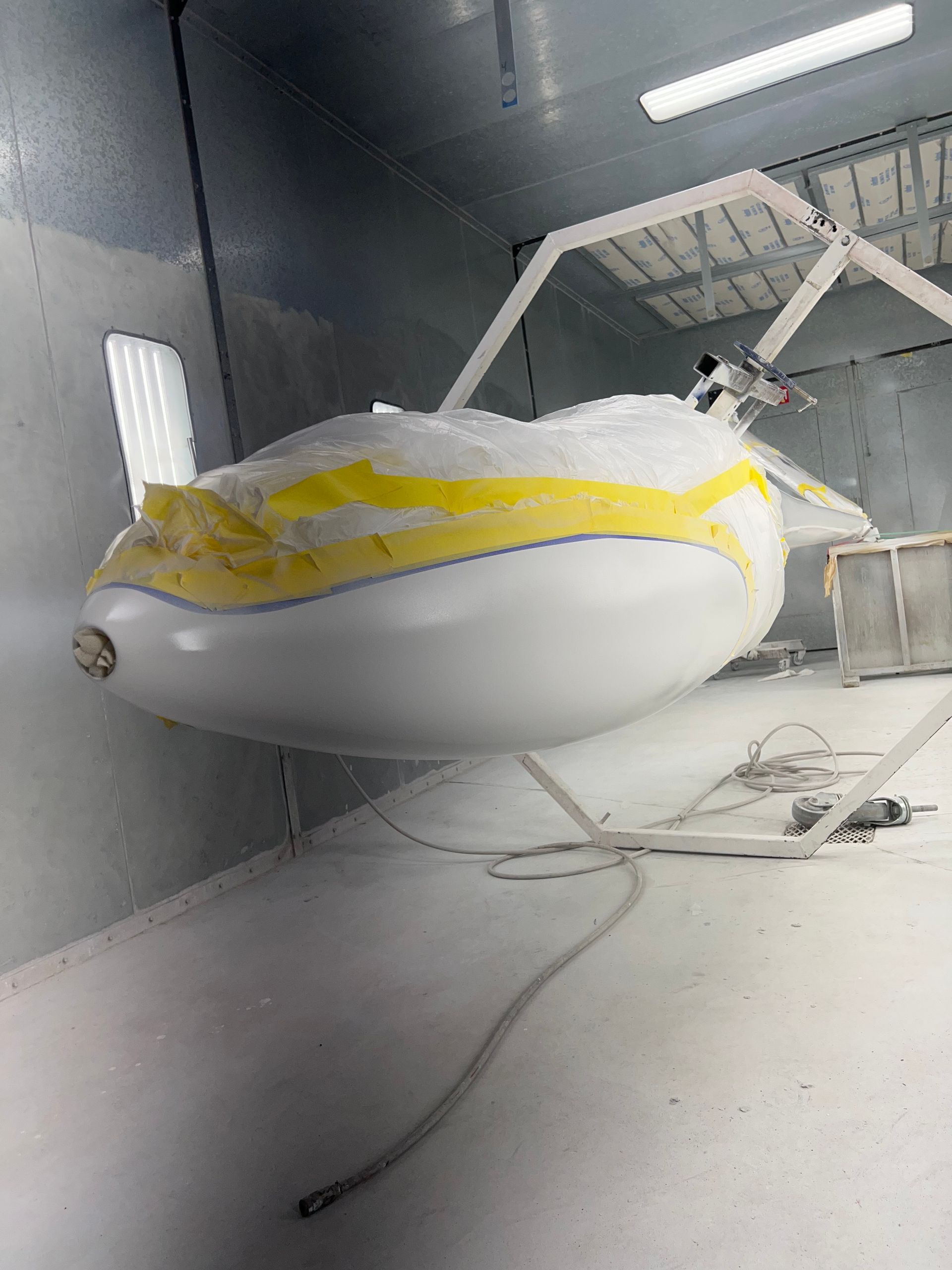 A small airplane is being painted in a paint booth.