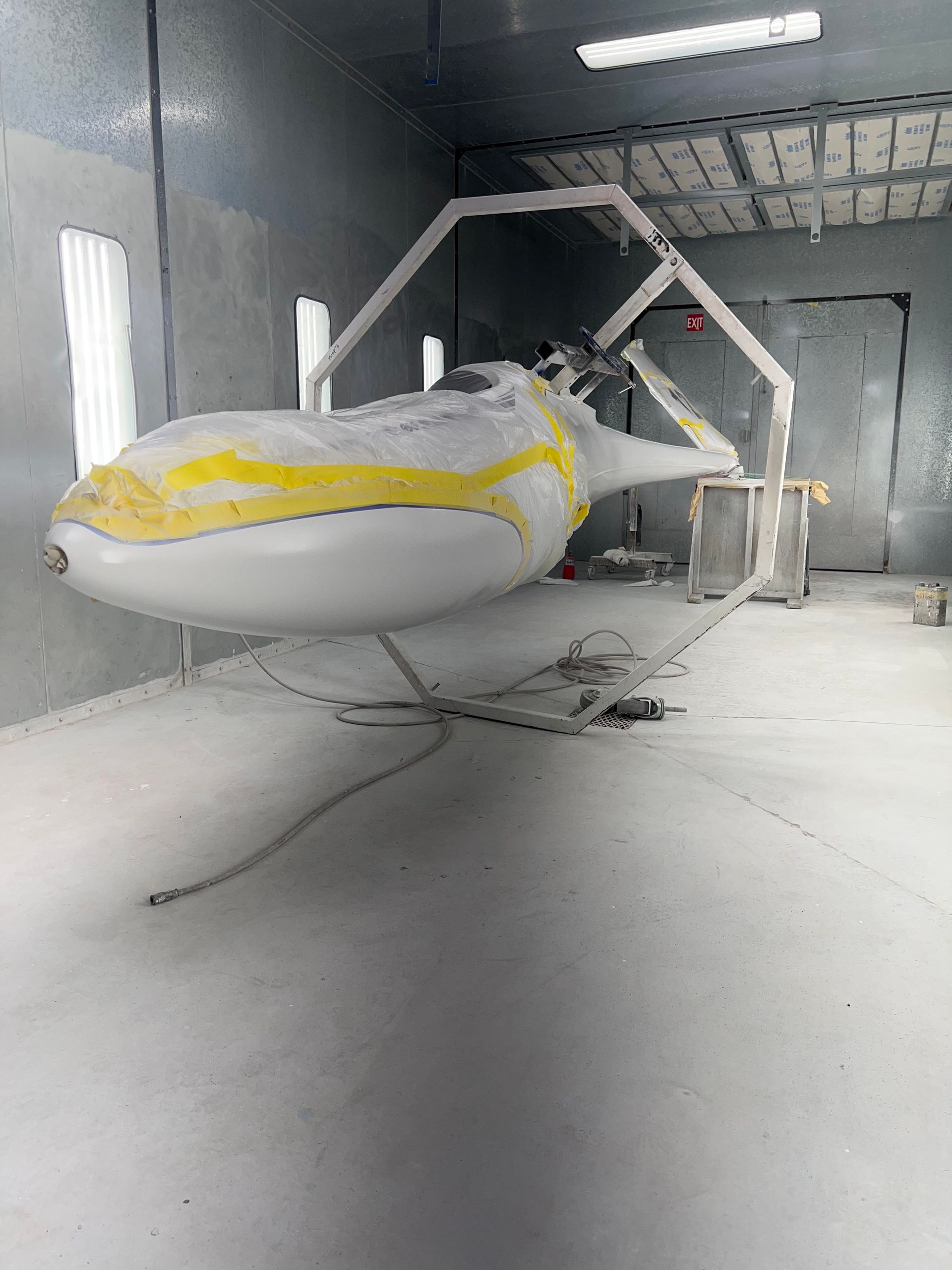 A jet ski is being painted in a paint booth.