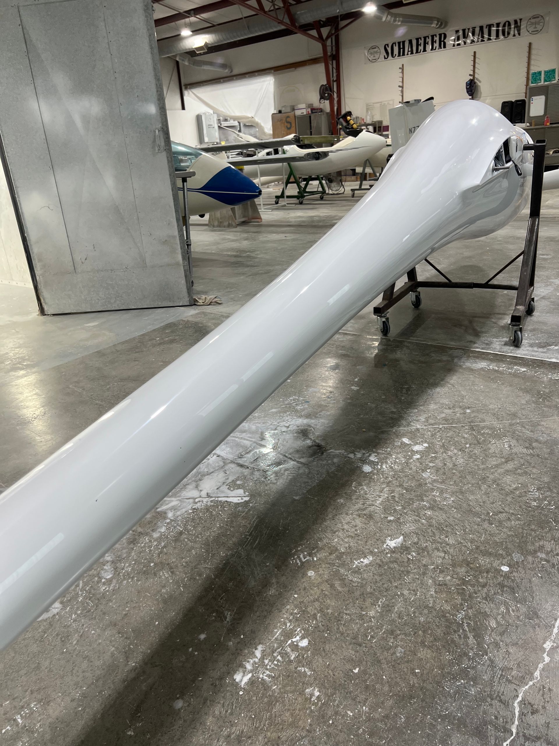 A white tube is sitting on a concrete floor in a warehouse.