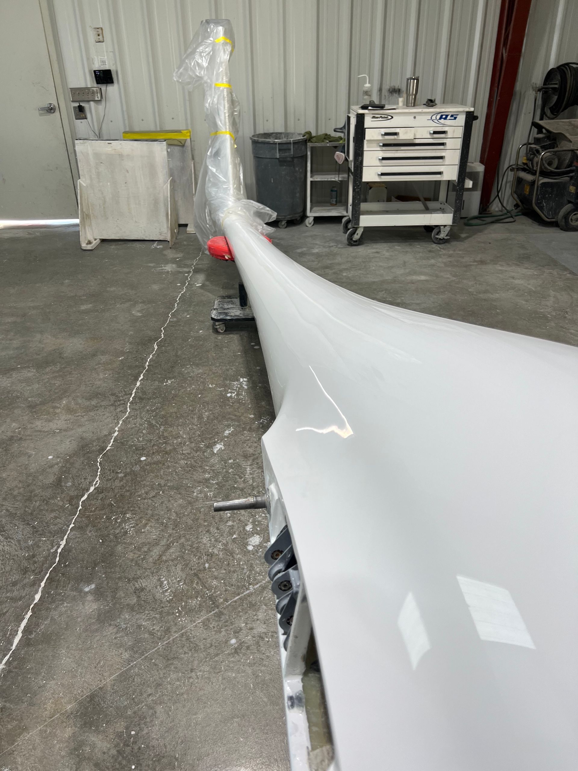 A white object is sitting on the floor in a garage.