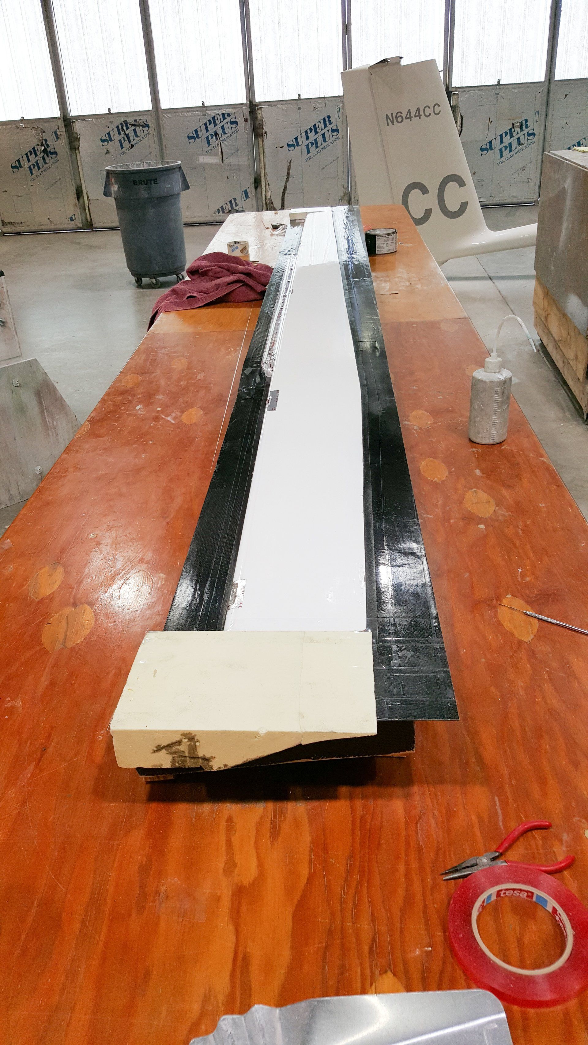 A long wooden table with a piece of foam on it.