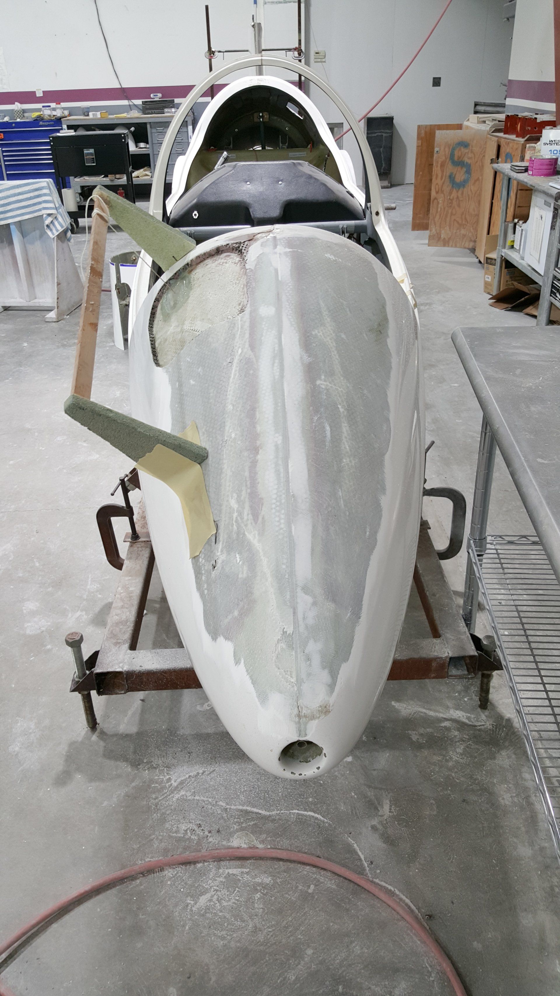 A small plane is sitting on a table in a warehouse.