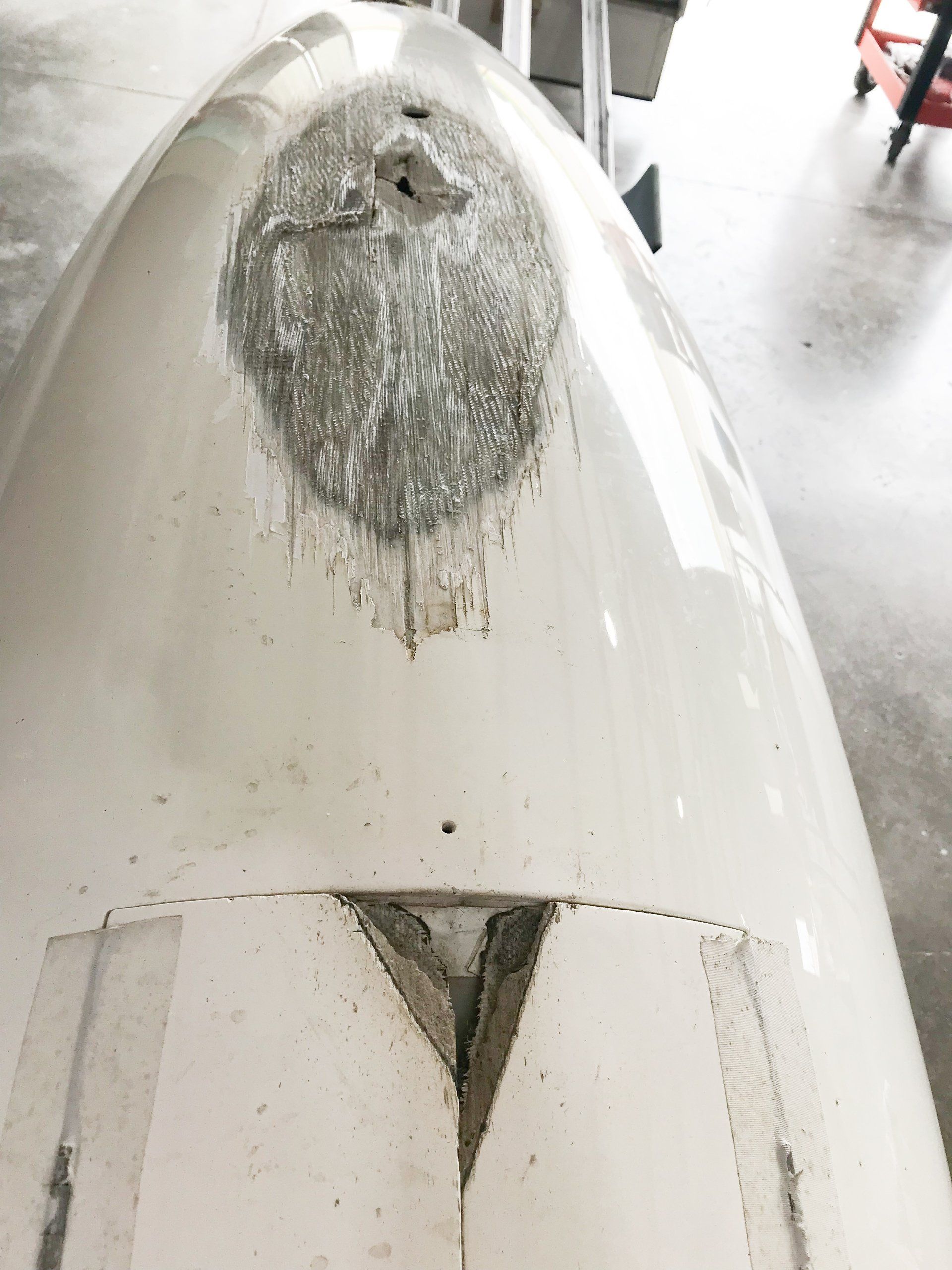 A close up of a white boat with a hole in it
