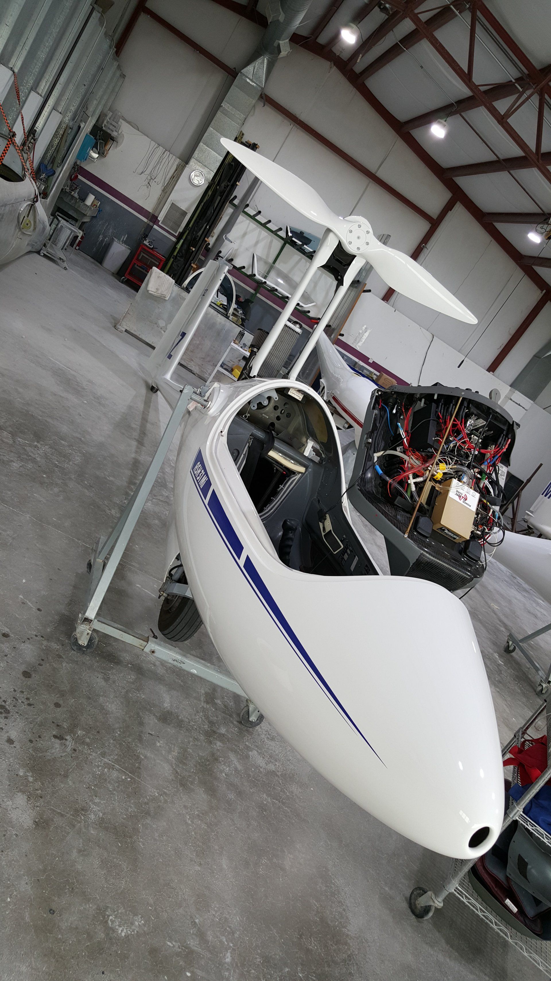 A small white plane is sitting on a stand in a hangar.