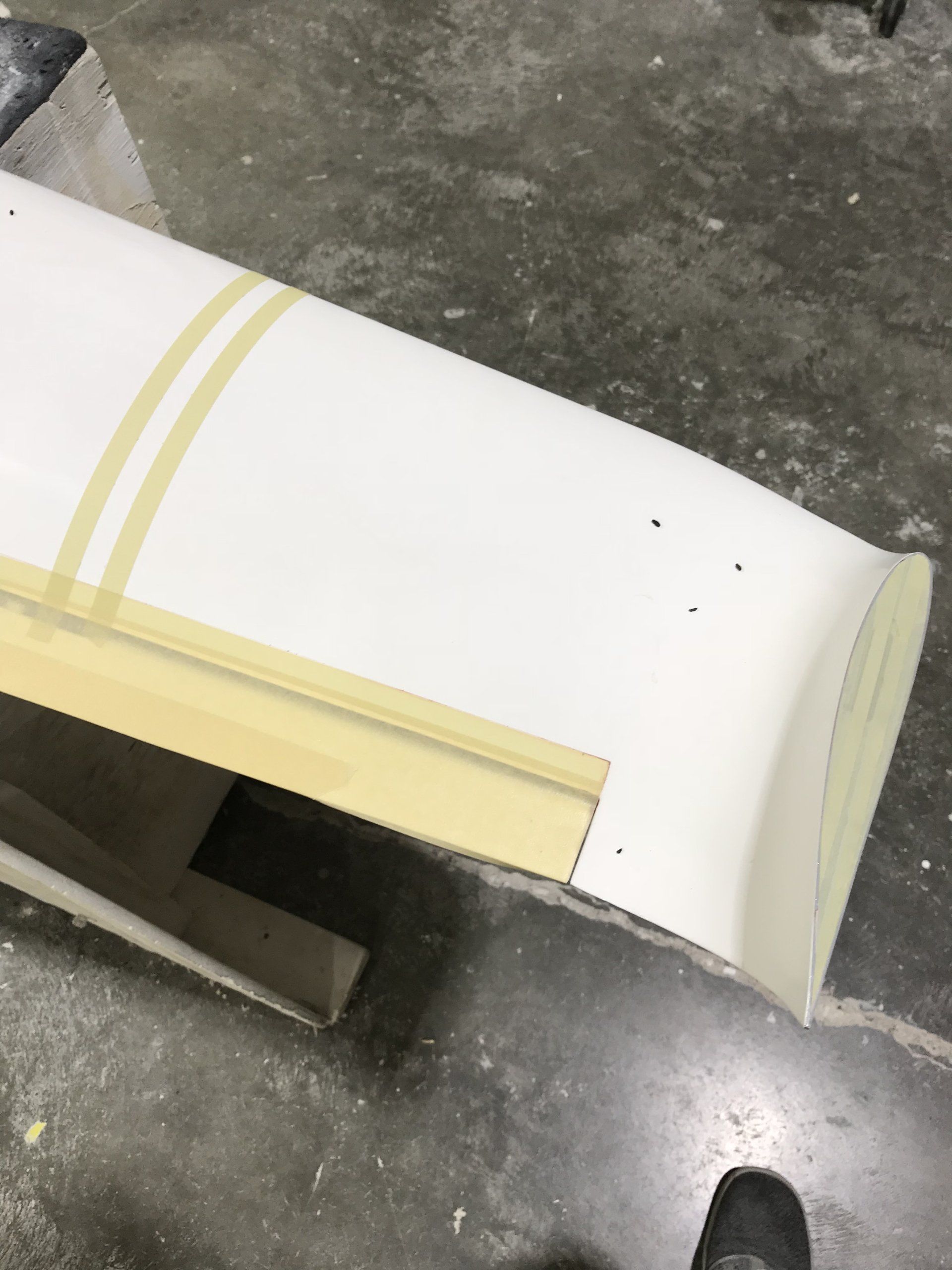 A piece of white plastic is taped to a concrete surface