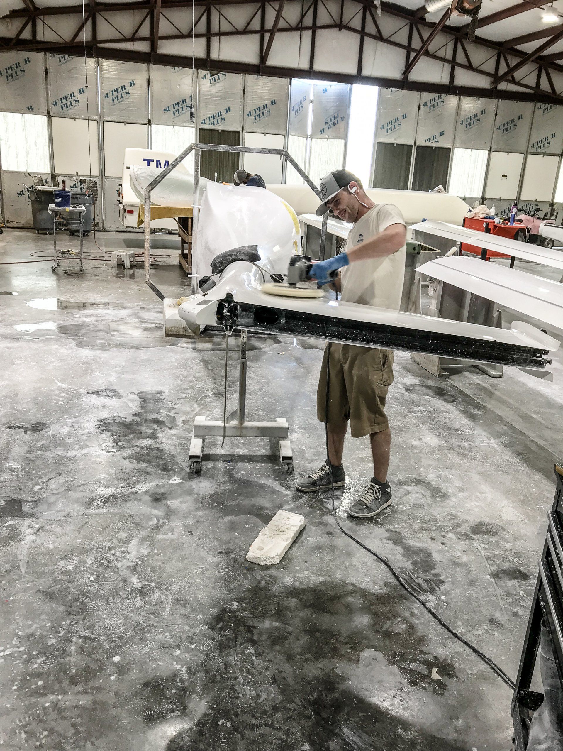 A man is working on a piece of wood in a factory.
