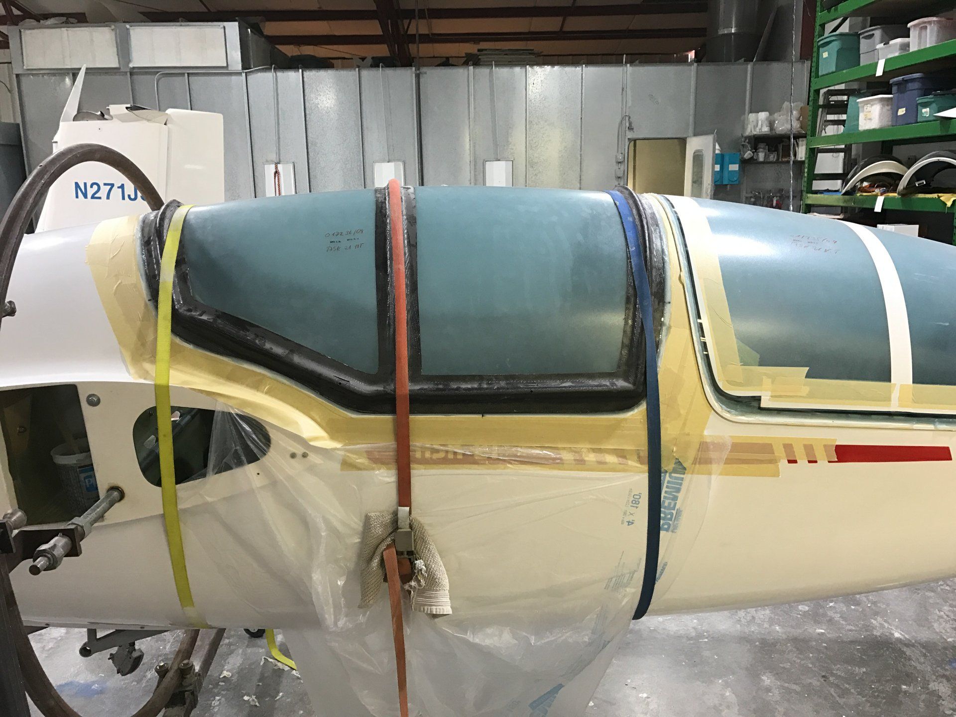 A white and blue airplane is sitting on a table in a garage.