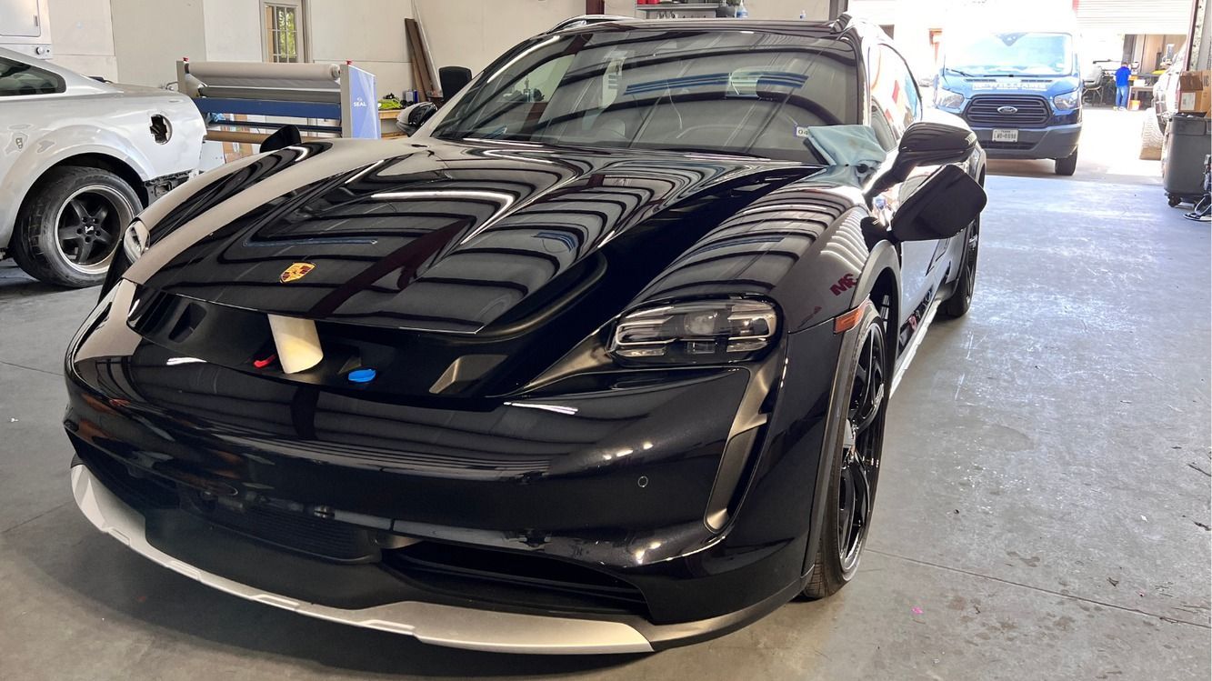 A black sports car is parked in a garage.
