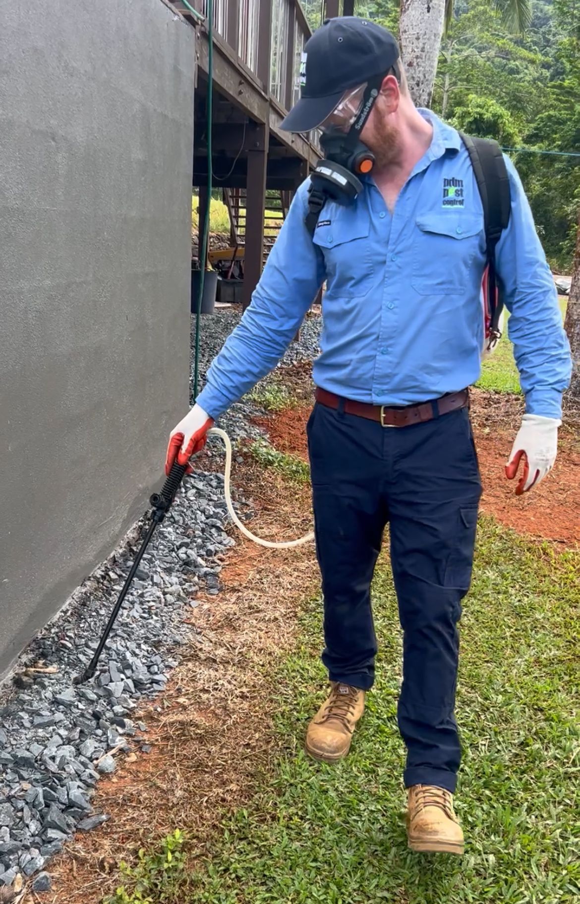 A Man Spraying Around The Outside Of A House — PDM Pest Control in Craiglie, QLD