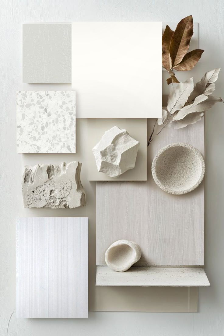 A collage of white tiles , rocks , and leaves on a white surface.