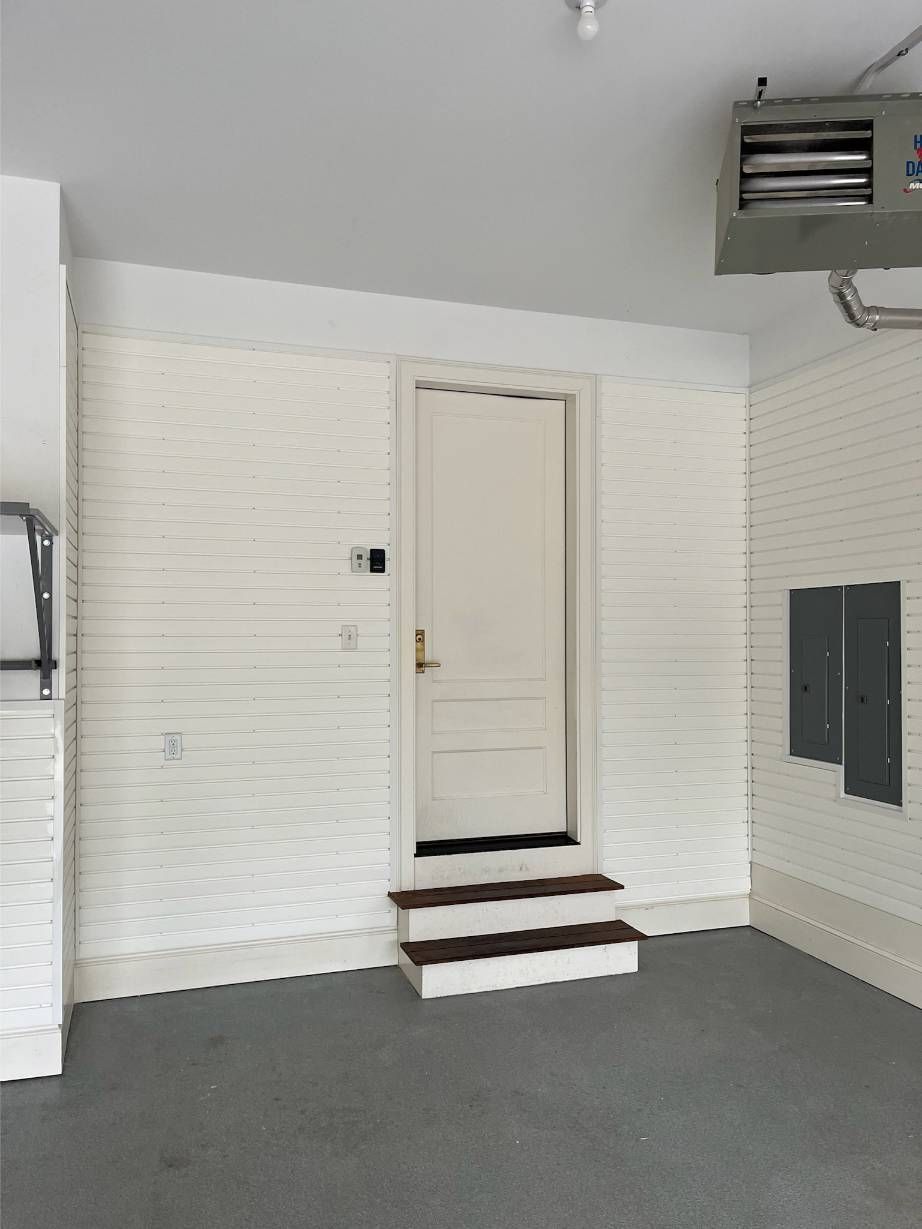 A garage with a door and stairs leading to it