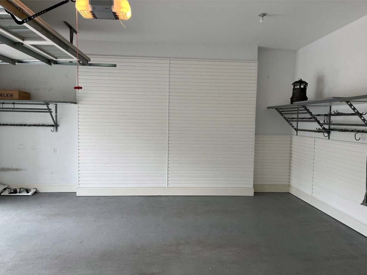 A garage with slatwall organizers a clock on the wall