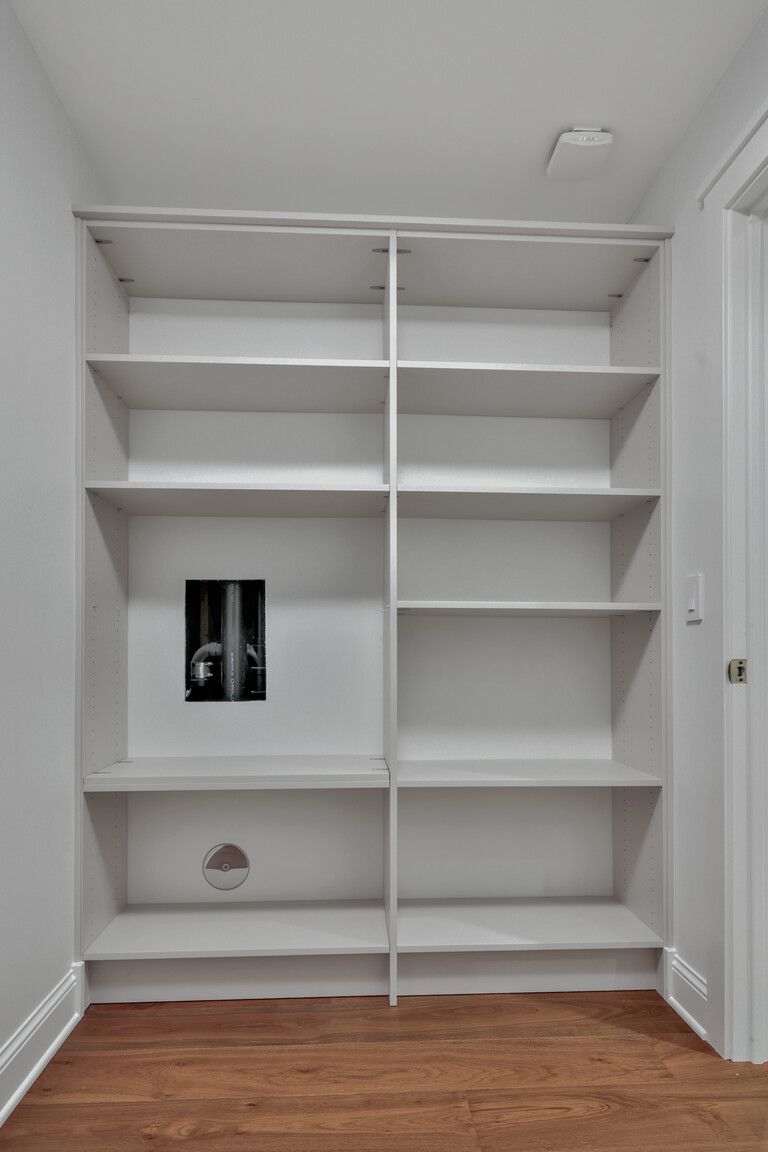 A room with a lot of shelves and a picture on the wall.