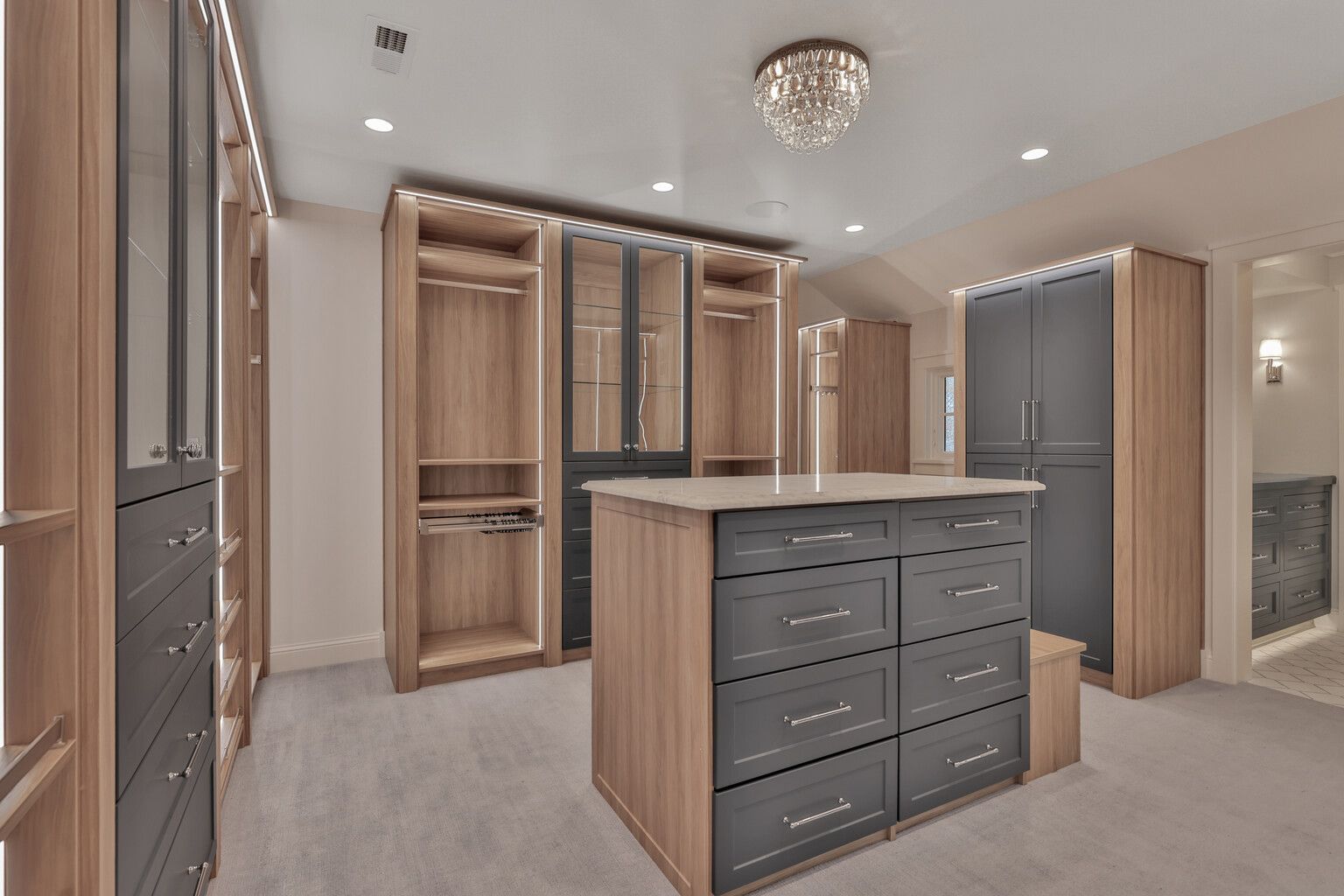 A large walk in closet with a large island in the middle.