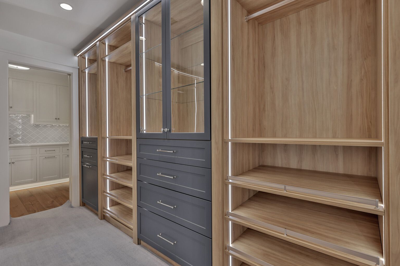 A walk in closet with lots of shelves and drawers.